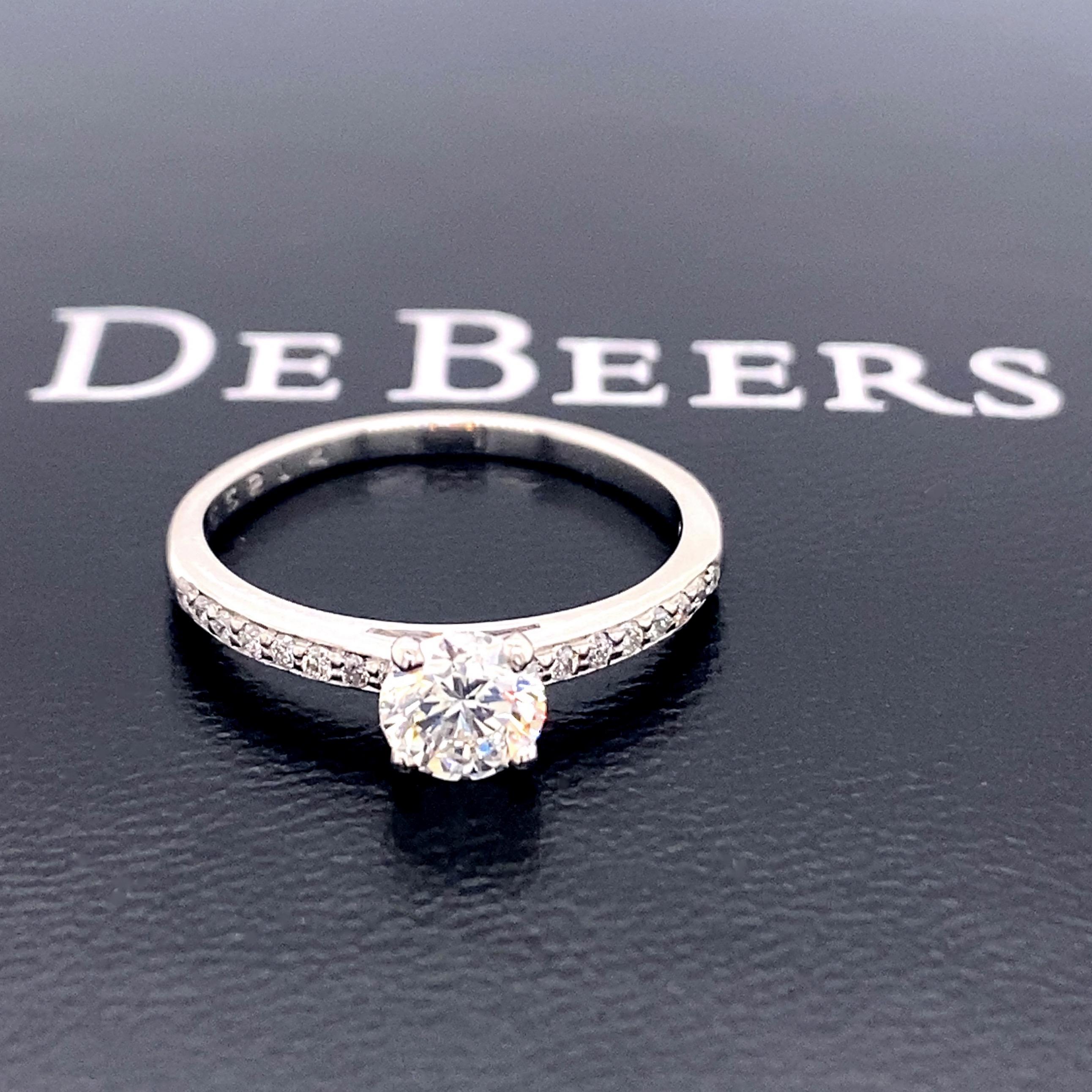 De Beers Forever Pave Diamond Engagement Ring 
Ref. number:  A55214
Metal:  Platinum PT950
Size: 6 sizable
TCW:  0.68 tcw
Main Diamond:  Round Brilliant 0.56 ct
Color & Clarity:  G, VS1
Accent Diamonds:   16 Round Brilliant Diamonds 0.12 TCW
Color &