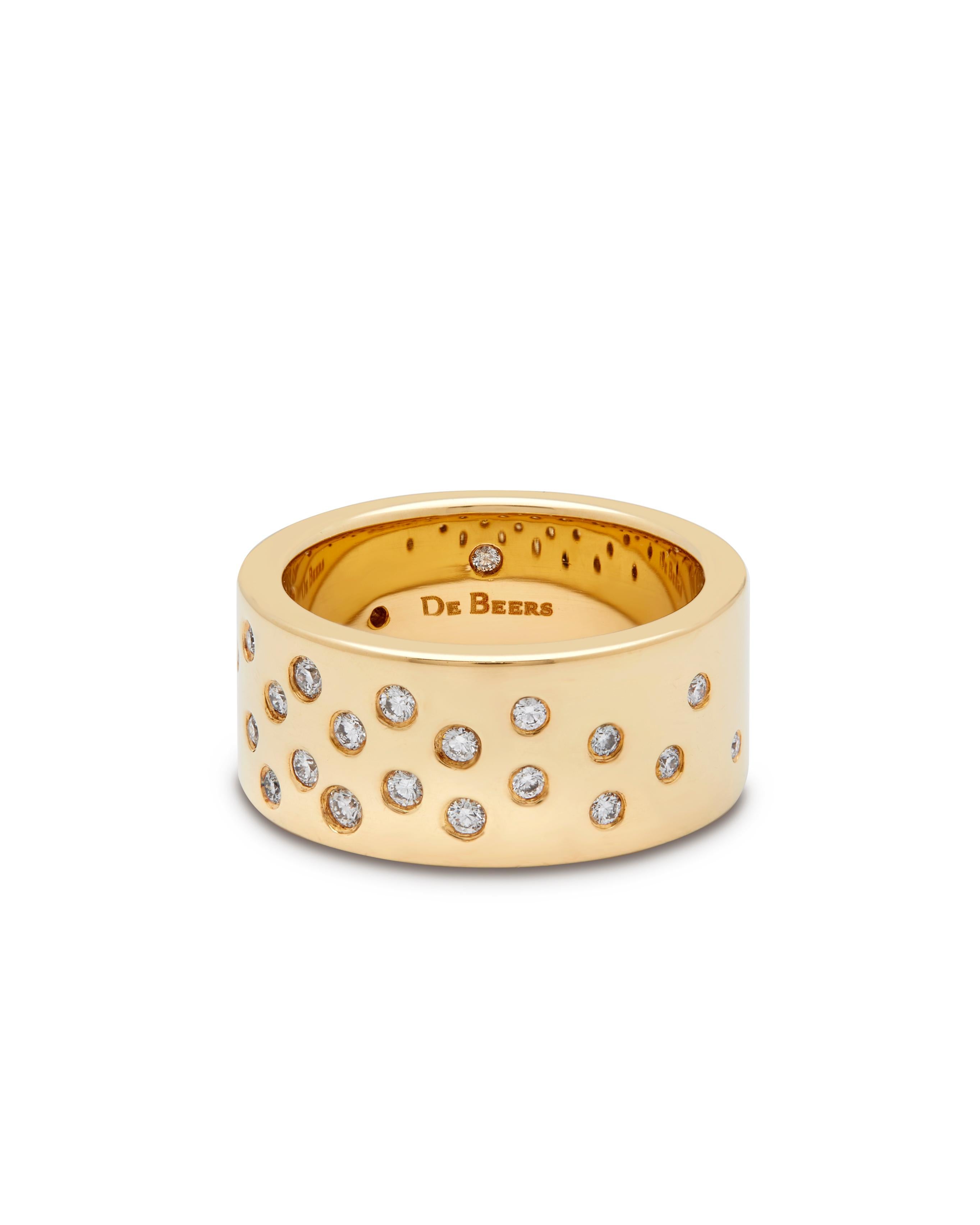 De Beers 18ct yellow gold diamond band ring.

The ring is sprinkled with 26 round brilliant cut diamonds rub-over set throughout, with 1 hidden on the inside of the band, with an approximate total weight of 0.47ct, F-G colour and VS clarity. 
The