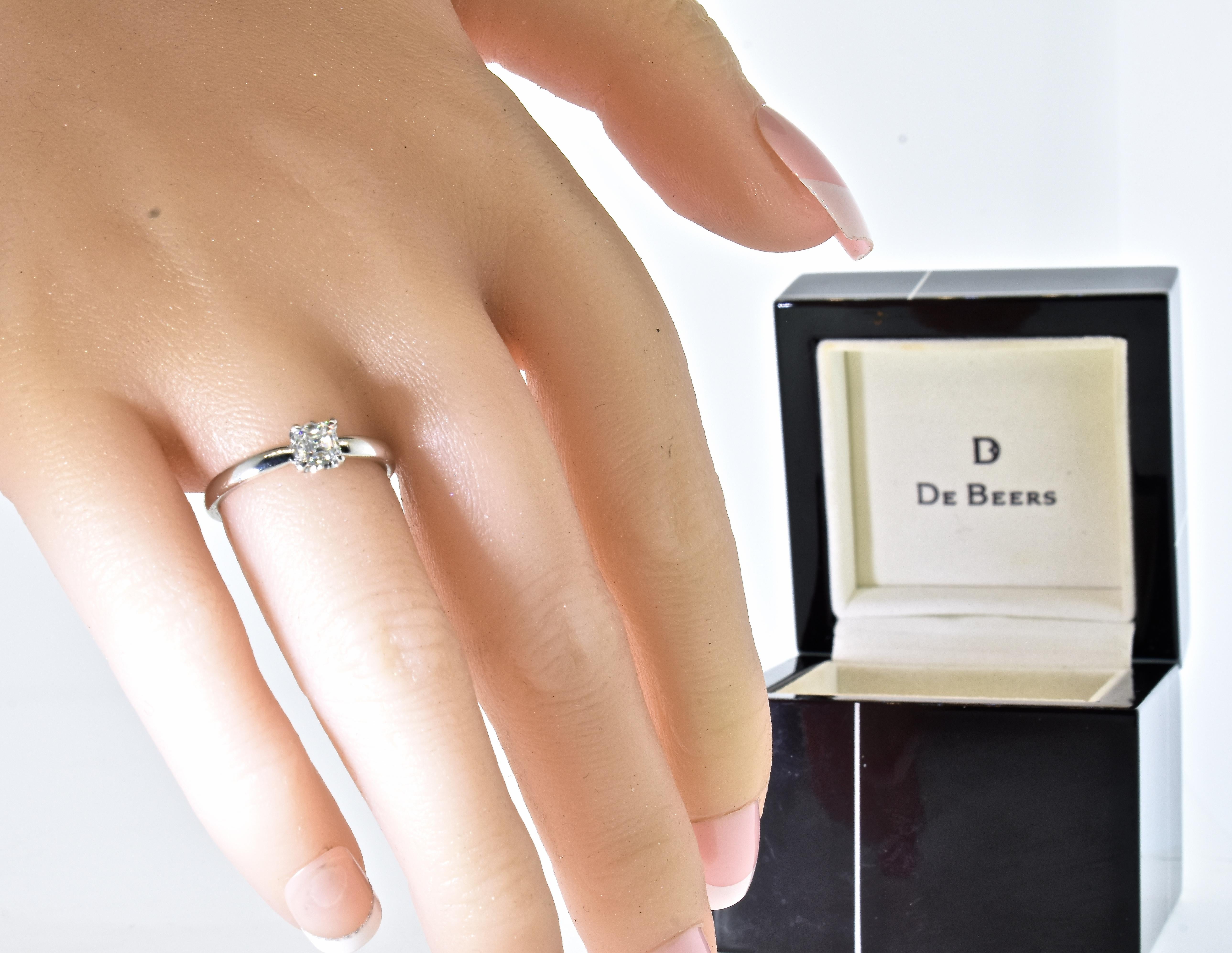 De Beers diamond solitaire platinum ring.  The center prong set square cut diamond is estimated by our internal gemologist to be very white - F/G (colorless to near colorless), and very very slightly included.  This very fine diamond is estimated to
