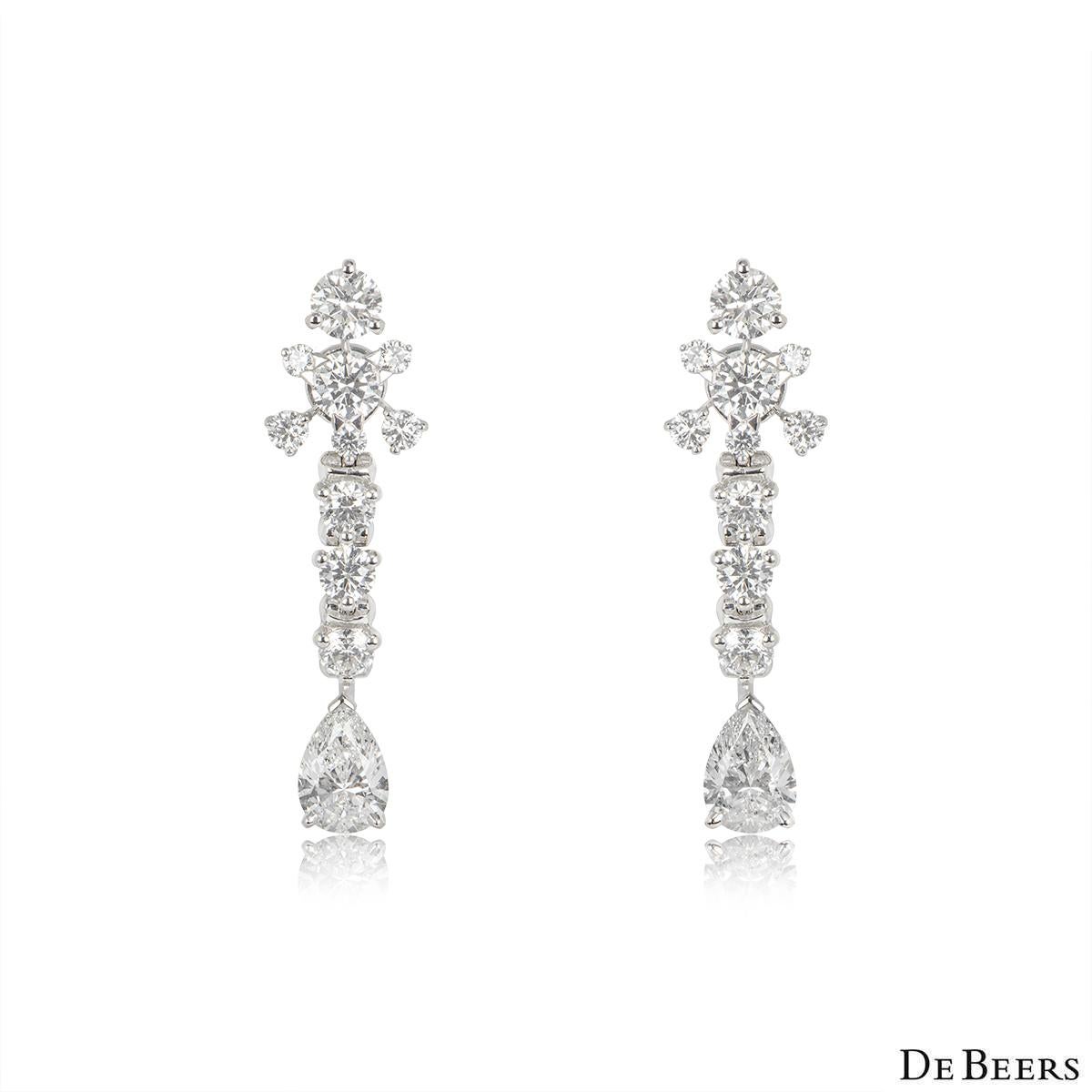 A stunning pair of platinum diamond Lea earrings by De Beers from their Couture Collections. Each earring is prong set to the top with 7 round brilliant cut diamonds in a star motif, followed by 3 round brilliant cut diamonds and a pear cut diamond.
