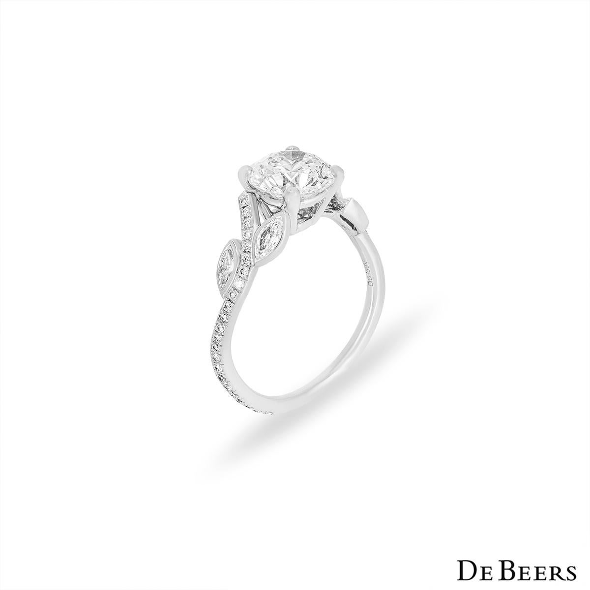A platinum diamond ring from The Adonis Rose collection by De Beers. The central diamond weighs 1.04ct, is E colour and VS1 clarity. The centre stone is enhanced by the graceful diamond pave set mount, composed of round brilliant and marquise