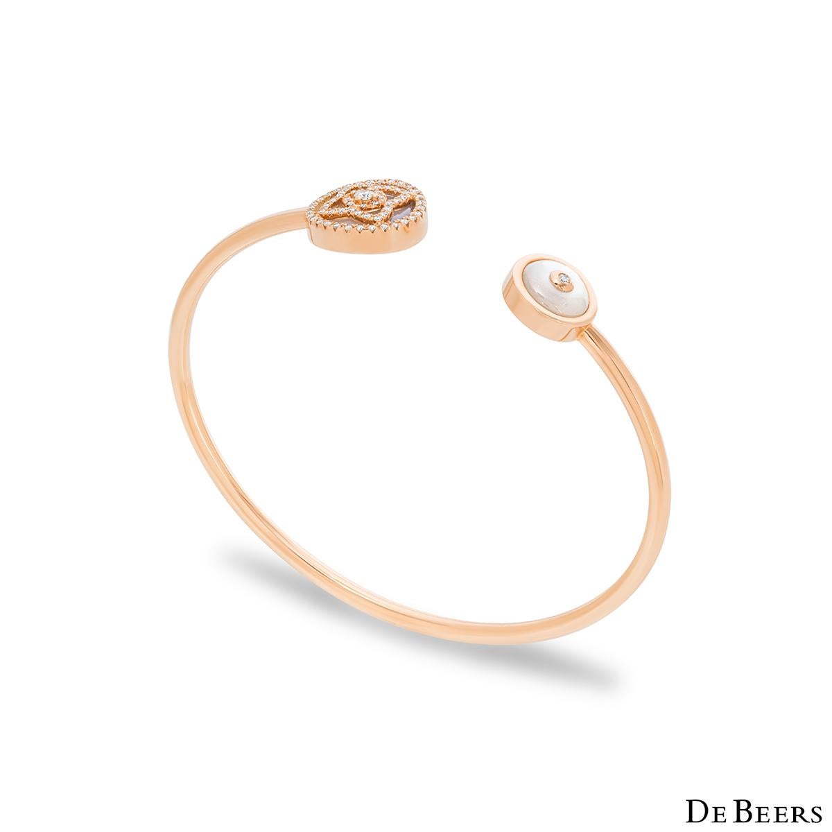 An elegant 18k rose gold mother of pearl and diamond Enchanted Lotus bracelet by De Beers. The cuff style bracelet features the iconic Enchanted Lotus motif on one end, pave set over a white mother of pearl inlay with 63 round brilliant cut