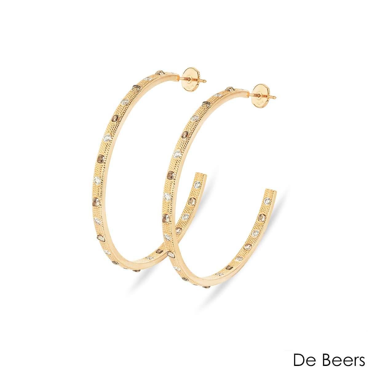 Un paio di scintillanti orecchini a cerchio con diamanti in oro rosa 18k di De Beers della collezione Talisman. Gli orecchini sono caratterizzati da diamanti grezzi e lucidi con una superficie a texture, ciascuno con 11 diamanti grezzi e 12 diamanti