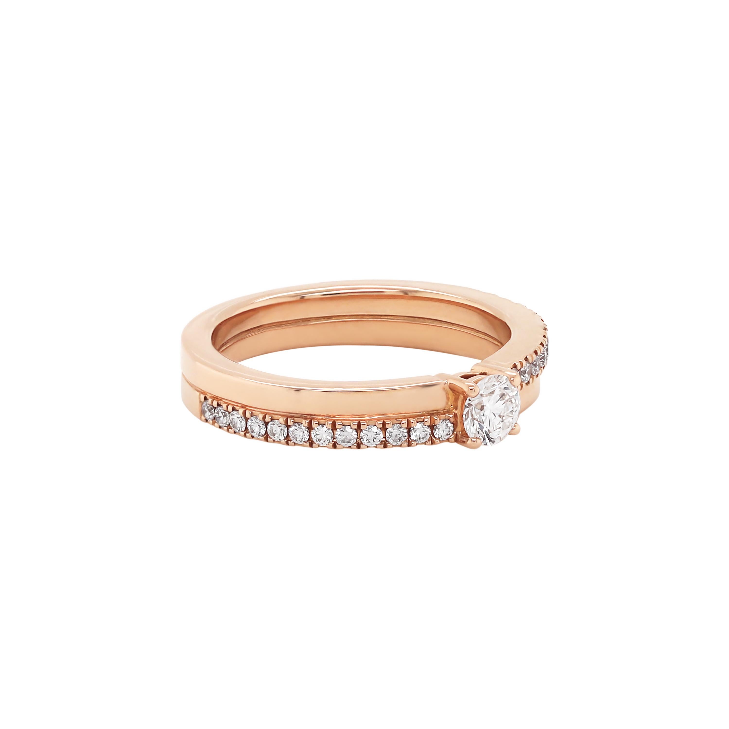 This elegant ring created by British designer, De Beers is composed of two independent interlocking bands. One is a plain 18 rose gold band, while the other is claw set with a delicate row of round brilliant cut diamonds, 12 on each shoulder.