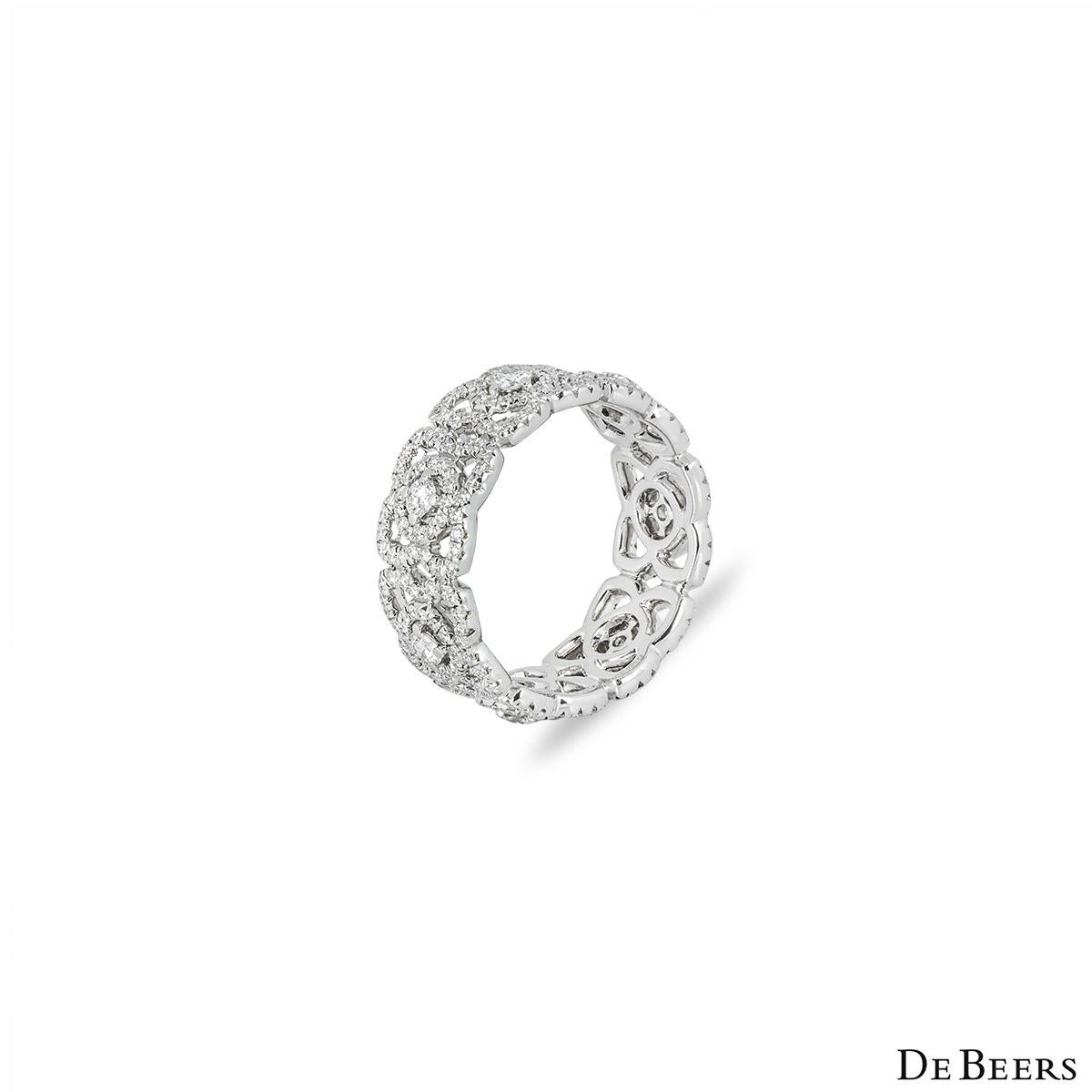 An elegant 18k white gold diamond ring by De Beers from the Enchanted Lotus collection. The band is set with 7 openwork lotus motifs pave set throughout with 301 round brilliant cut diamonds with an approximate total weight of 1.22ct, E-G colour and