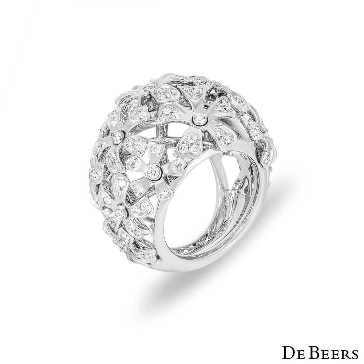 A unique 18k white gold diamond dress ring by De Beers. The ring features an openwork flower design set with round brilliant cut diamonds. The ring sits at 9mm above the finger and measures 2.6cm in width. The ring is a size UK size K/ EU size 50/
