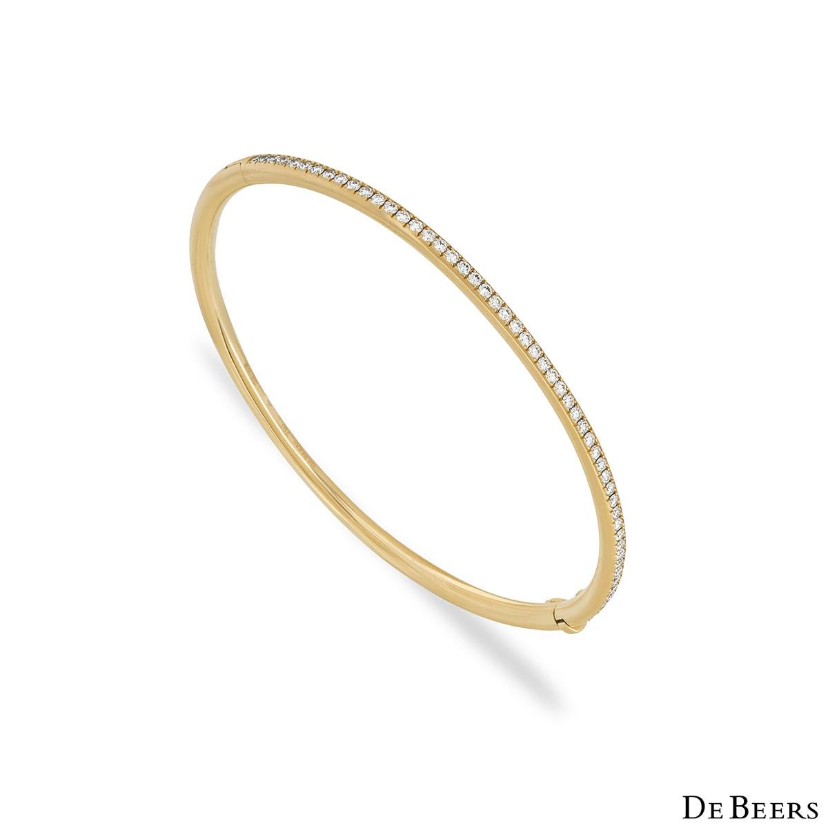 A timeless 18K yellow gold diamond bangle by De Beers from the Classics collection. This bangle features 52 micropavé set round brilliant cut diamonds totalling 0.64ct, predominately F-G colour and VS clarity. The bangle fits a wrist size of up to