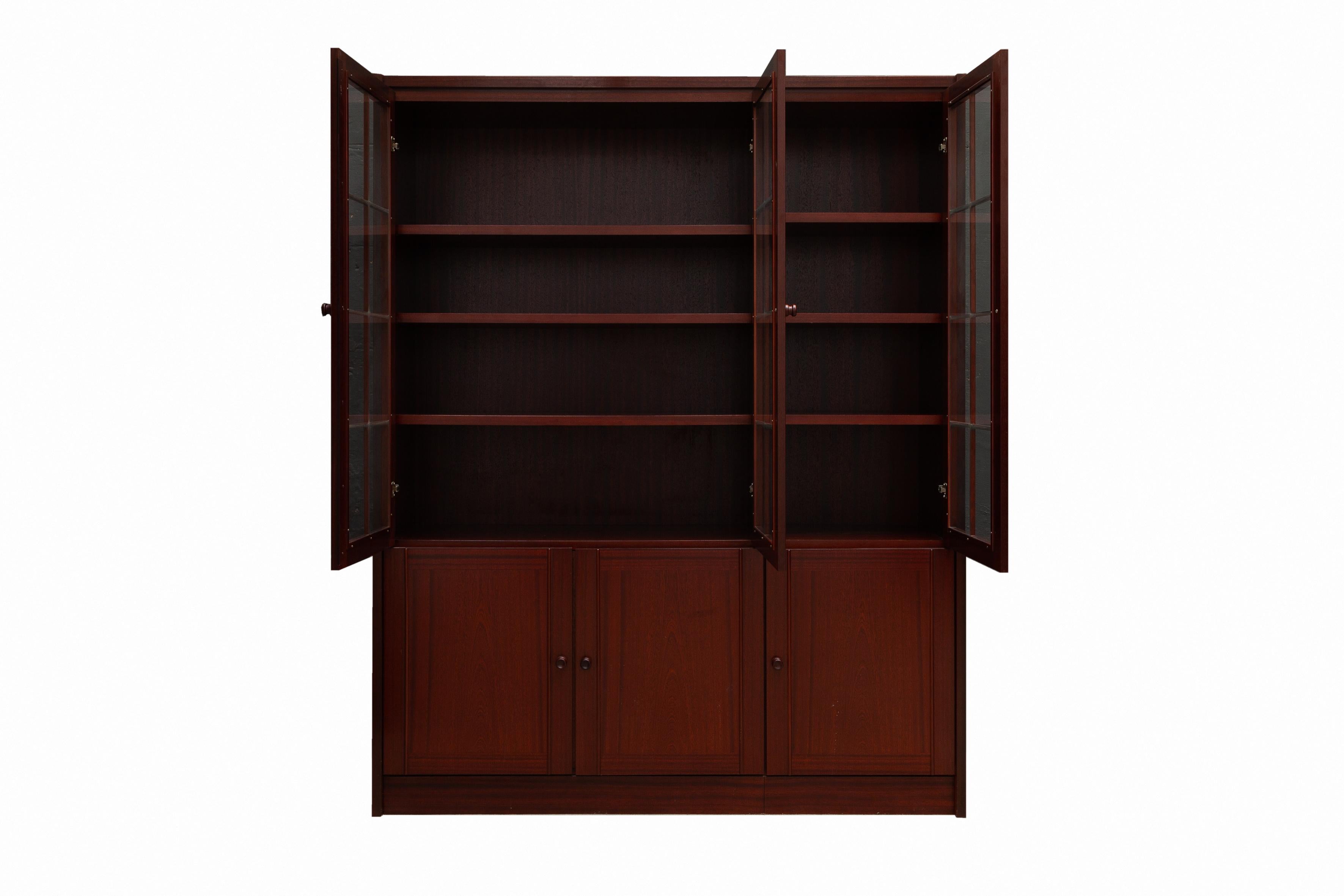 Vintage early 1970s bookshelf or display cabinet by De Coene, Belgium. This three door cabinet is made of solid wood with clear glass. The doors have magnetic closures. Moveable shelves. Excellent condition.
Dimension: 156 W x 194 H x 44 D cm.