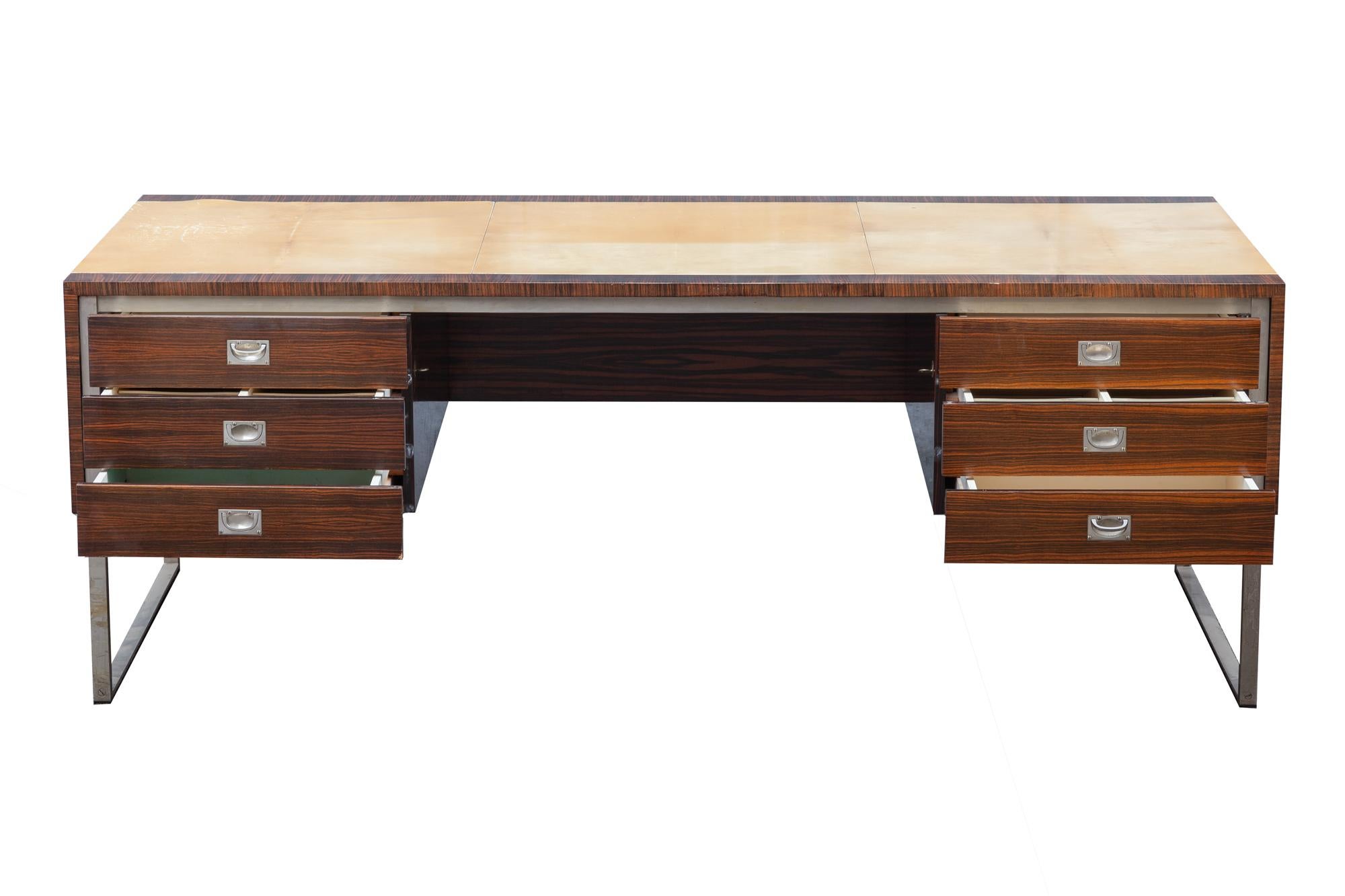 Vintage 1960s executive desk by De Coene, Belgium. Laminated tiger wood with parchment top. Glossy finish. Stainless steel chrome frame. 
Six locking drawers with organizational compartments for envelopes, pens etc.

Dimensions: 205 W x 74.5 H x 98