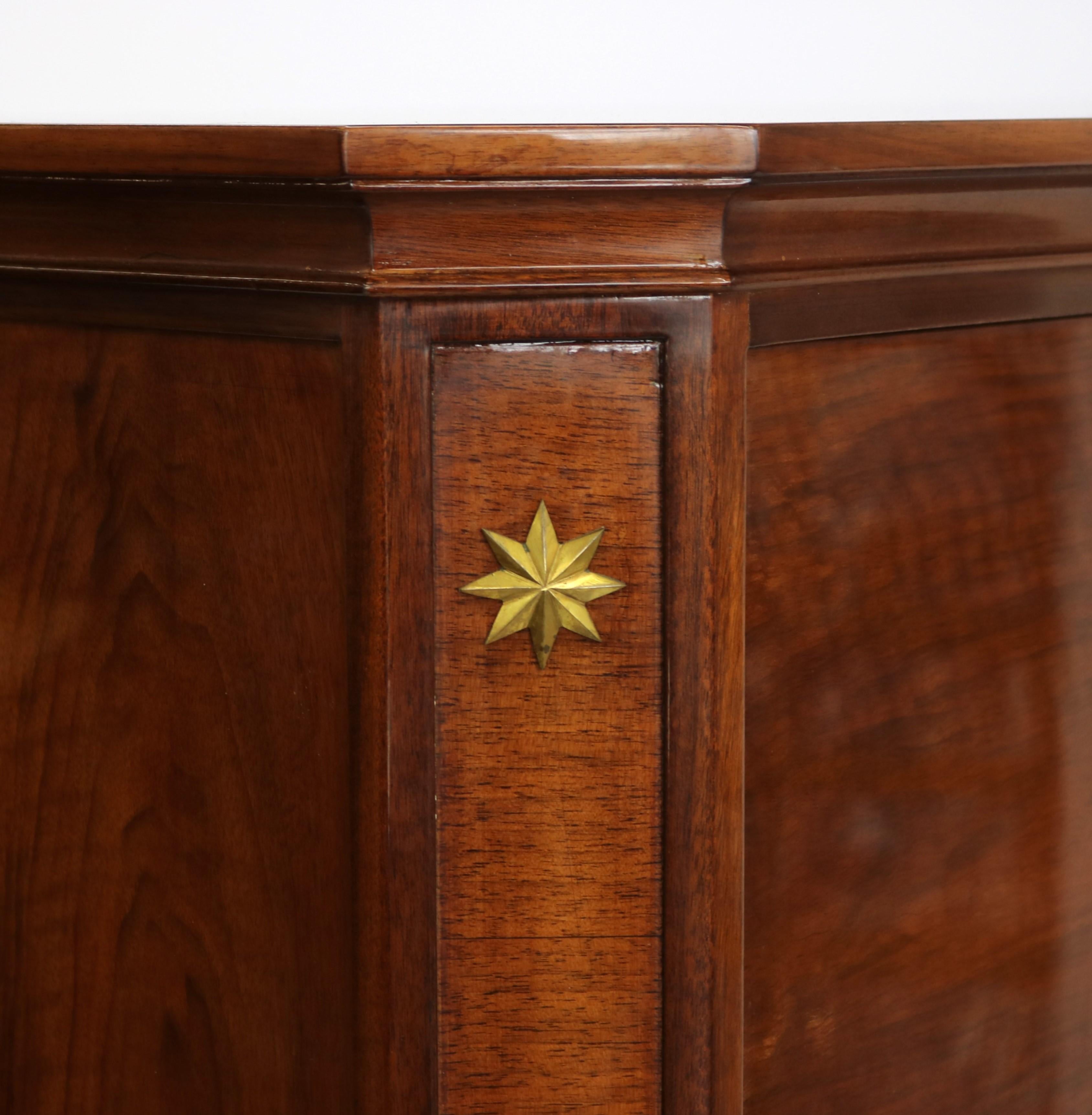 A De Coene Frères Art Deco period bar cabinet from Brussels, Belgium circa 1930. Walnut and walnut burl with original patinated bronze star medallions, sabots and details. The upper cabinet is a drop front that reveals a mirror back with beautiful