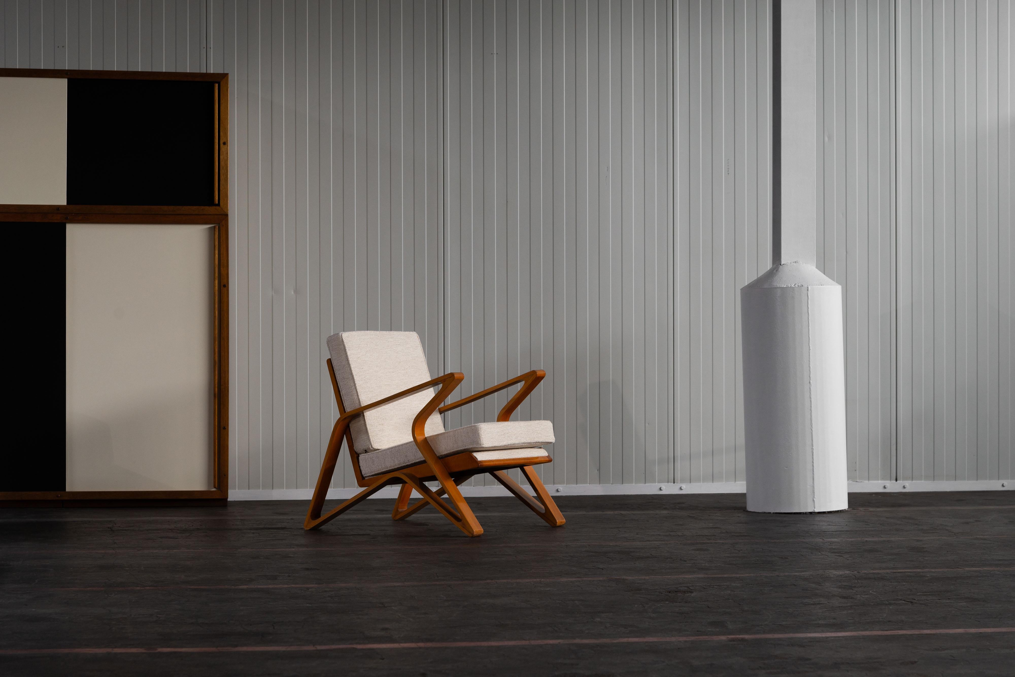 Chaise de salon étonnante et super rare conçue par De Coene Frères, Courtrai Belgique dans les années 1950. Cette chaise a une structure en hêtre dans une teinte orange-brune chaleureuse. Pour préserver l'authenticité de cette pièce, les coussins