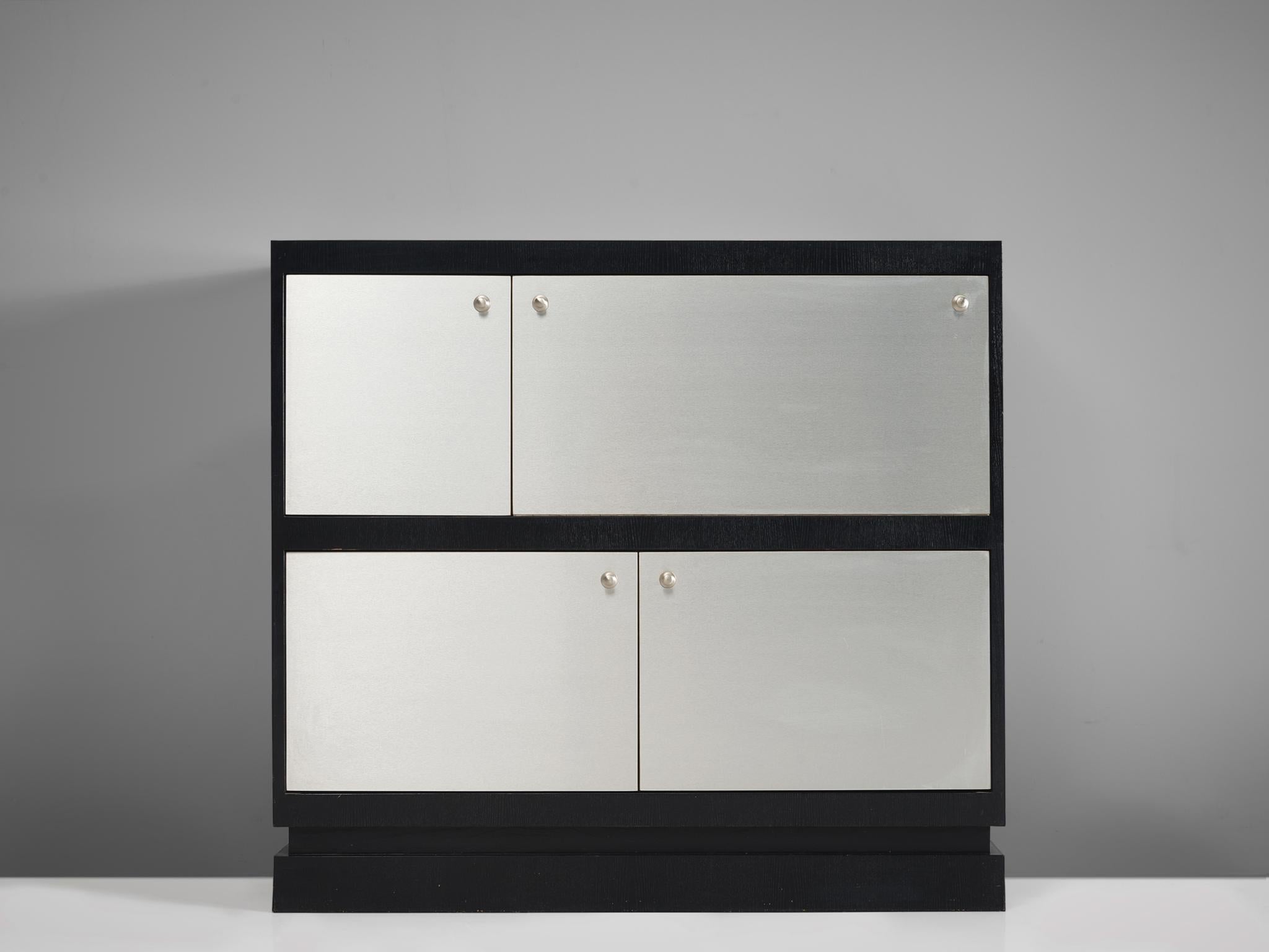 De Coene, cabinet, plywood, aluminum, Belgium, 1970s.

This Postmodern cabinet is manufactured by De Coene and is furnished with aluminium plated doors and handles. The cabinet is divided in four asymmetrical doors of which the biggest is folding