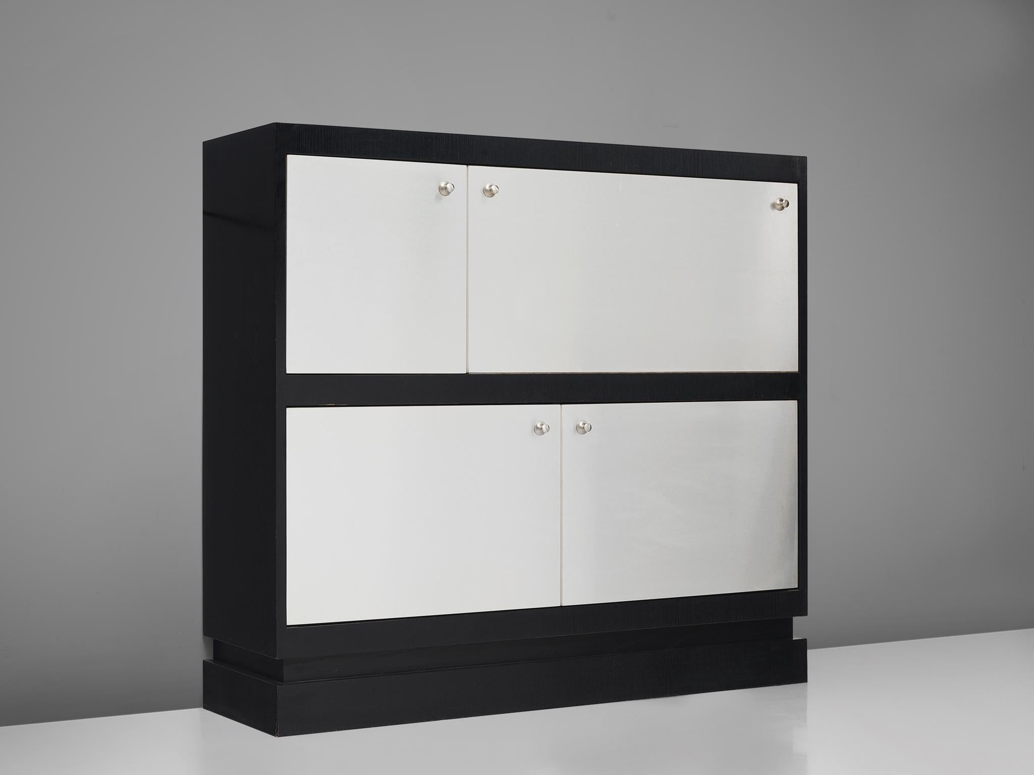 De Coene, cabinet, lacquered ash, brushed aluminum, Belgium, 1970s.

This Postmodern cabinet is manufactured by De Coene and is furnished with aluminium plated doors and handles. The cabinet is divided in four asymmetrical doors of which the