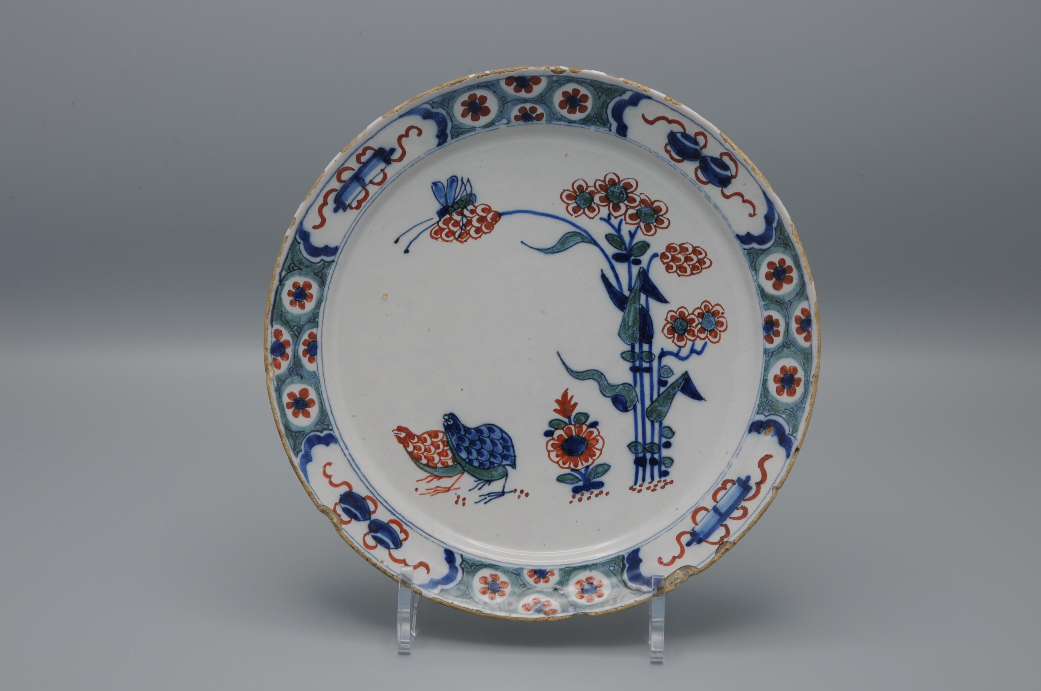 Rare assiette en faïence du début du 18e siècle avec un décor rare  en bleu et rouge fer.

Marqué  