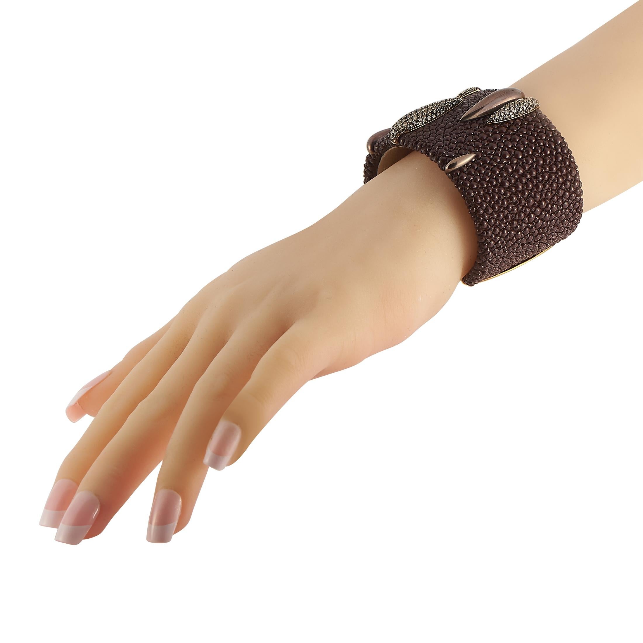 Reichhaltige Materialien machen dieses opulente De Grisogono-Armband wahrhaft atemberaubend. Ein strukturierter Sockel bildet den perfekten Hintergrund für die eleganten Akzente, die sich aus 18 Karat Gelbgold und Diamanten mit einem Gesamtgewicht