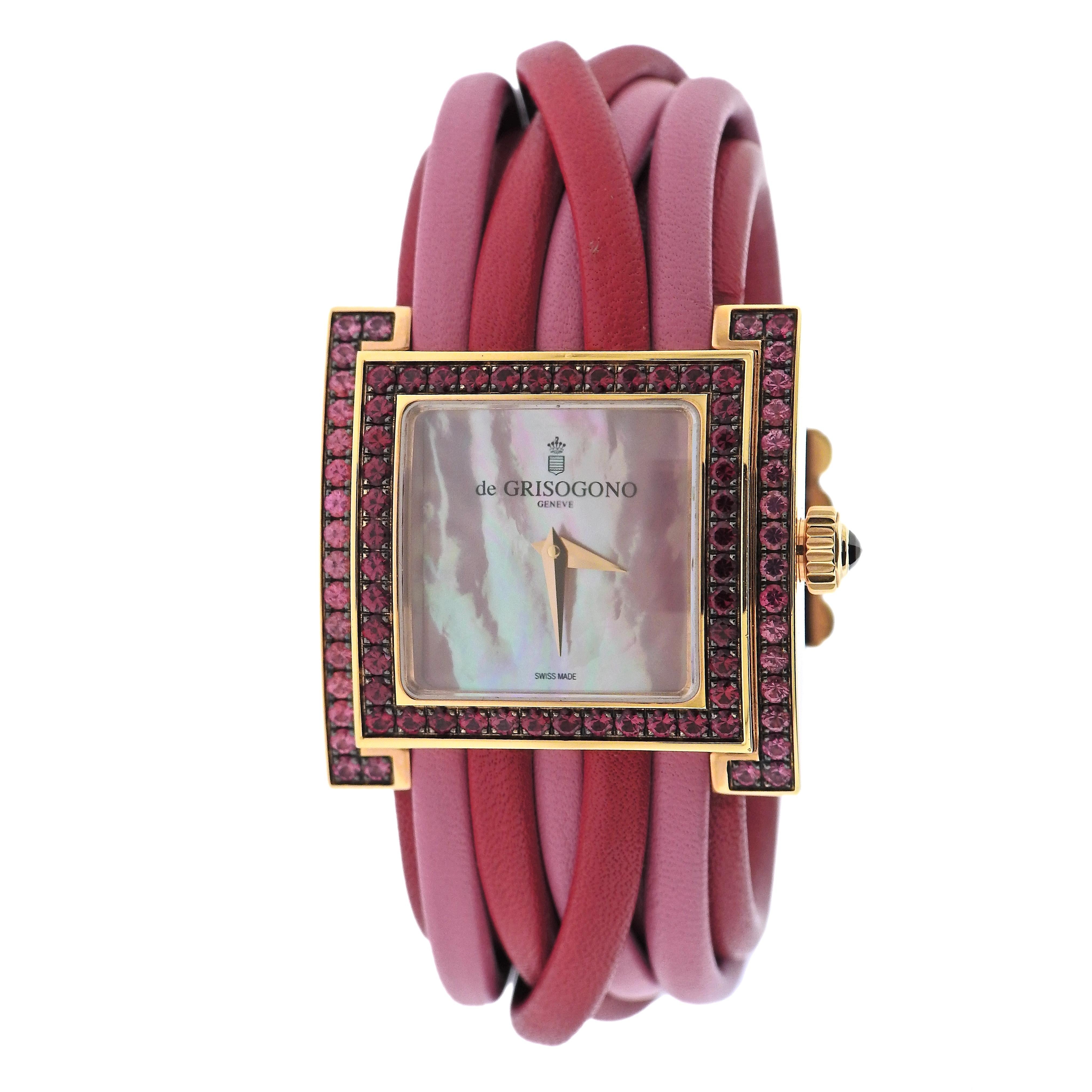 New with tag de Grisogono Allegra watch, featuring 18k yellow gold case, adorned with rubies and pink sapphires, mother of pearl dial, pink and red leather bracelet. Quartz movement. Comes with box and papers. Case - 33mm excl. crown x 34mm.