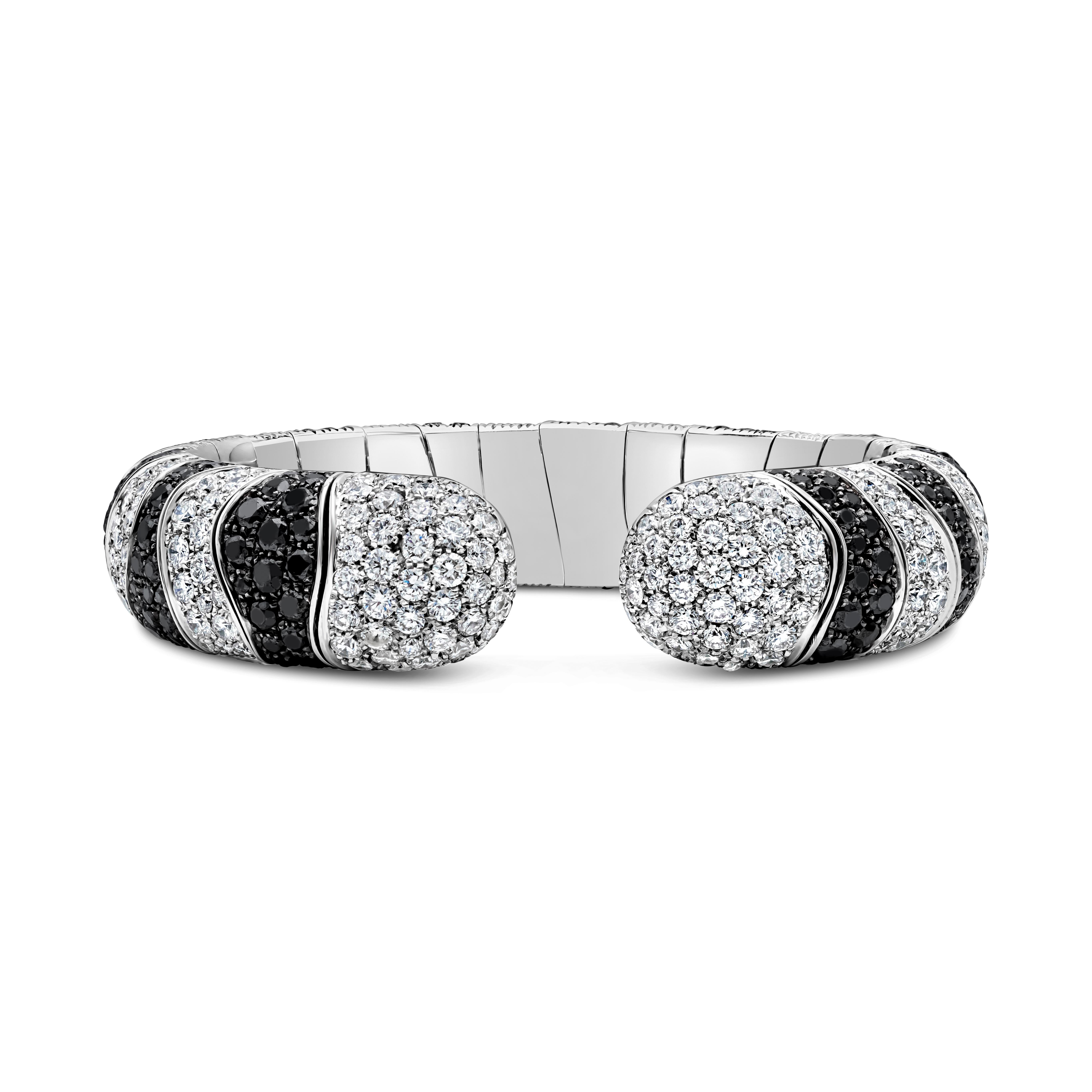 This semi-flexible cuff bangle bracelet showcases black and white diamonds set in 18 karat white gold. Black diamonds weigh 13.50 carats total. White diamonds weigh 11.00 carats total, F color and VS clarity. Bracelet made in 18 karat white gold.