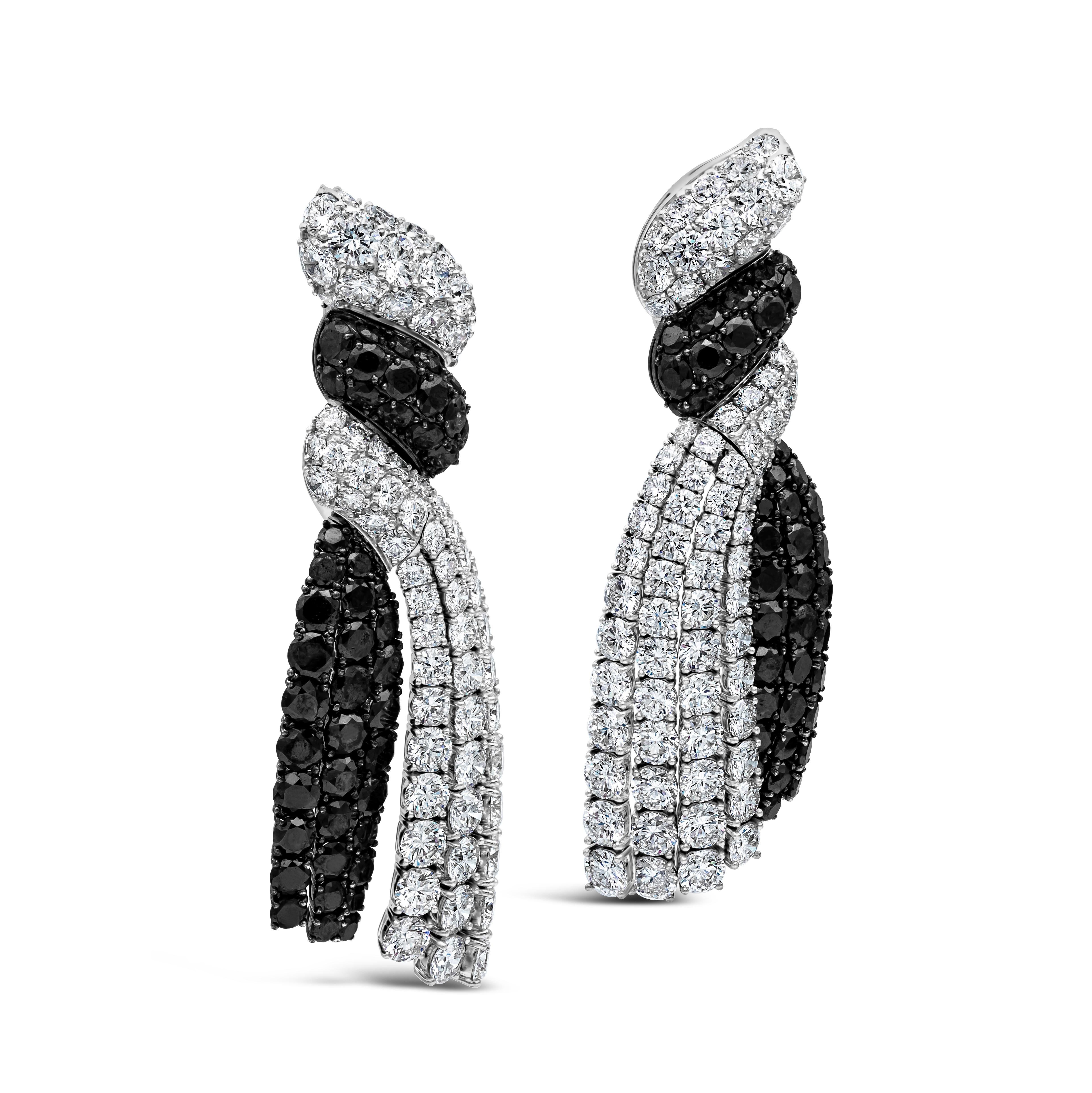 This stunning pair of dangle earrings showcases black and white diamonds in a twisted-like design. Black diamonds weigh 25.62 carats total. White diamonds weigh 39.10 carats total F-G Color and VS in Clarity. Earrings Made with 18K White Gold. Made