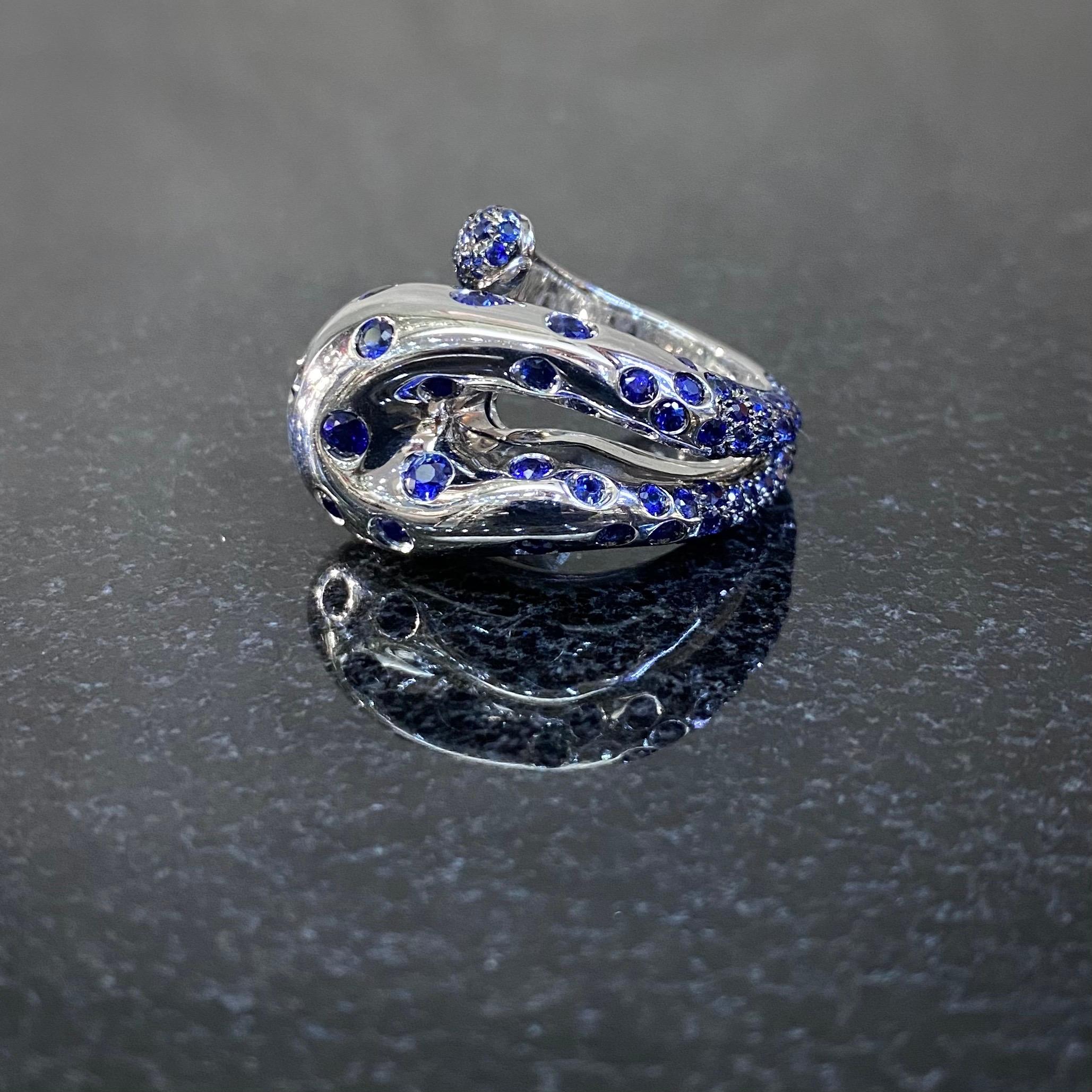 durchbrochener Cocktailring mit blauem Saphir und Schlange von de GRISOGONO aus 18 Karat Weißgold, um 2000. In Form einer abstrakten, durchbrochenen Schlange, die sich um den Finger schlängelt, ist der gewölbte Kopf dieses Rings durchgehend mit