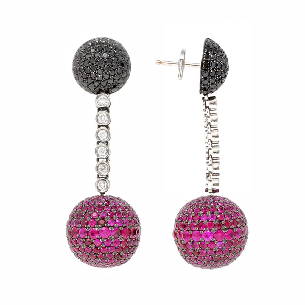 A pair of ruby and diamond dangling earrings signed de GRISOGONO circa 1990. The iconic Boule earrings created by the famous house of jewelry are composed of a half ball of black diamonds pave tops and a sphere of vibrant rubies set in a circular