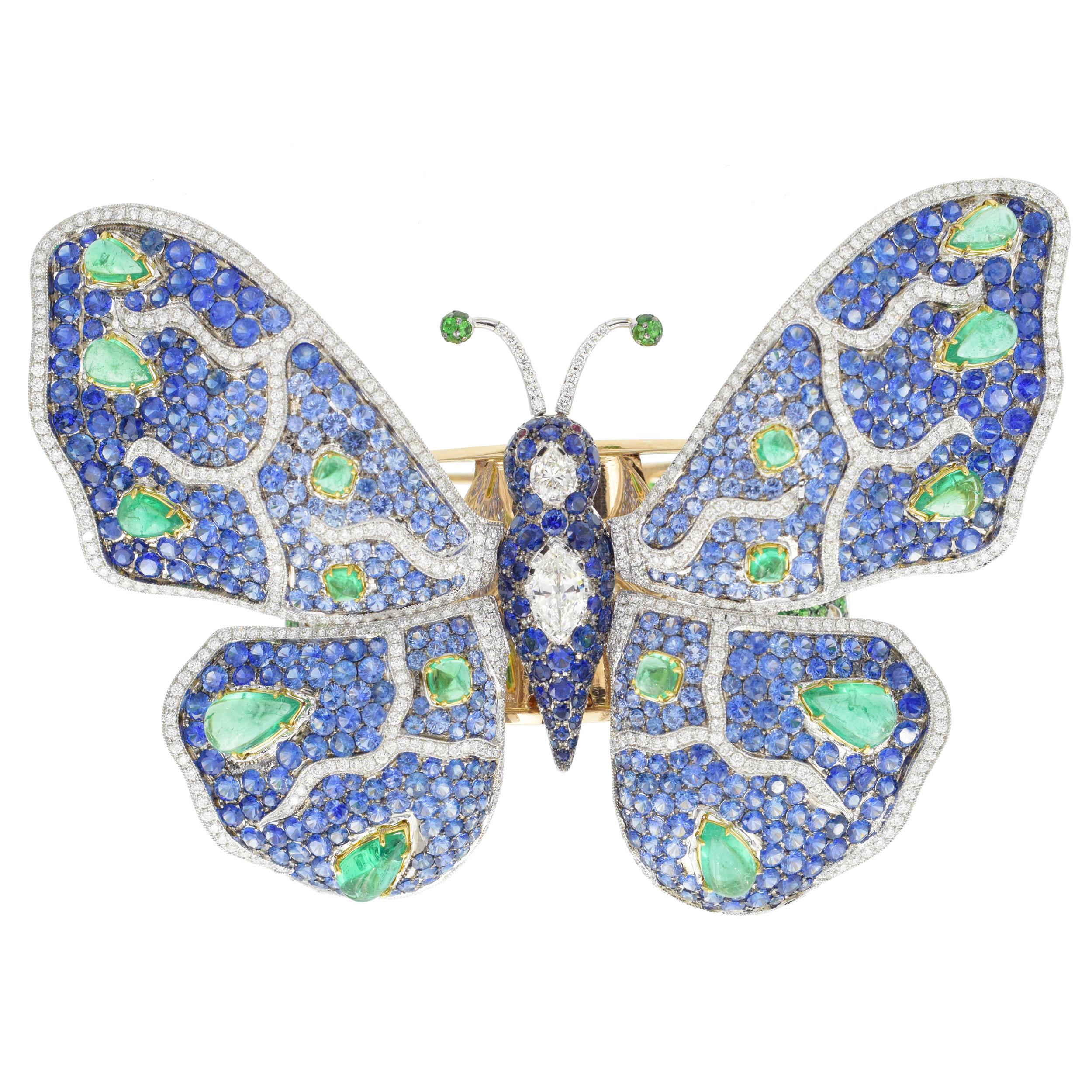 De Grisogono diamond and gemstone butterfly bangle in 18k yellow gold. The butterfly is set with 1.01ct pear marquise cut diamond and 0.35ct pear shape diamond. Encrusted with round cut blue sapphires with total weight of 52.26ct, cabochon cut