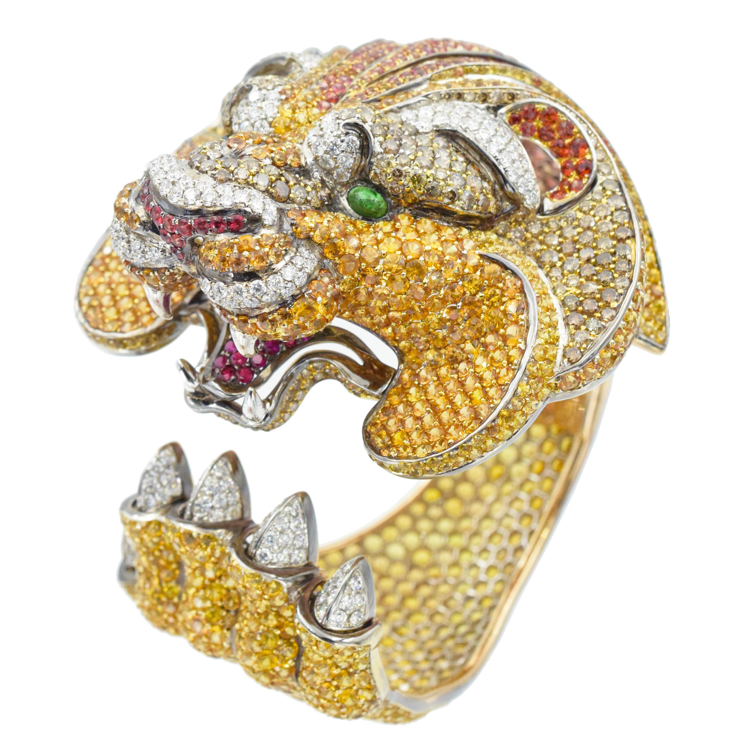 De Grisogono Diamond and gemstone lion cuff bracelet crafted in 18k gold. The design features lion head on one and a claw on the other end. Encrusted with 5.30ct of white round brilliant cut diamonds, 8.90ct of round brilliant cut brown diamonds,