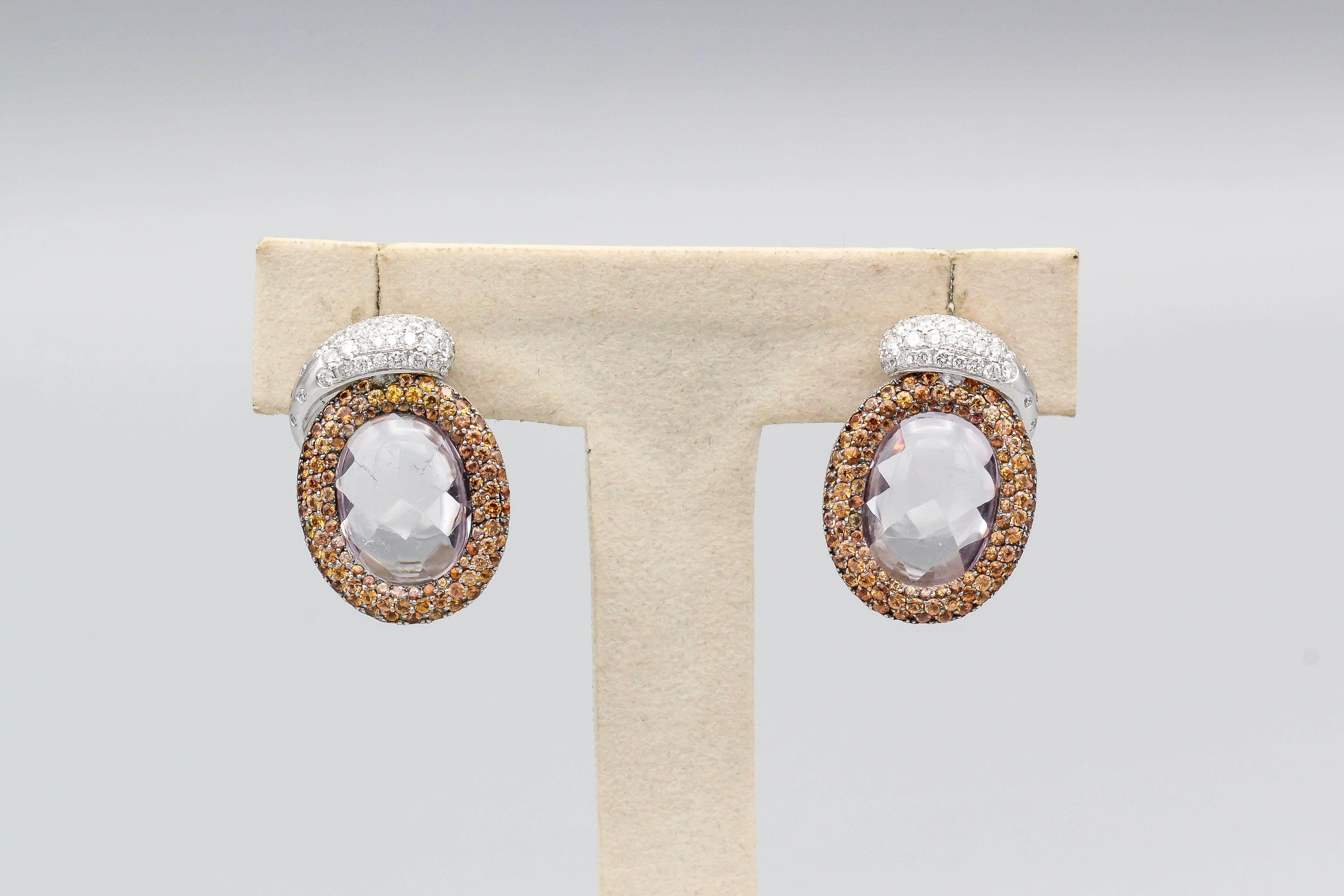 Fine pair of 18K white gold reversible earrings by de Grisogono. The earrings are set with a central kunzite stone that is faceted on one side and cabochon smooth on the other.  They featured a mechanism where the earrings can be worn to show an all