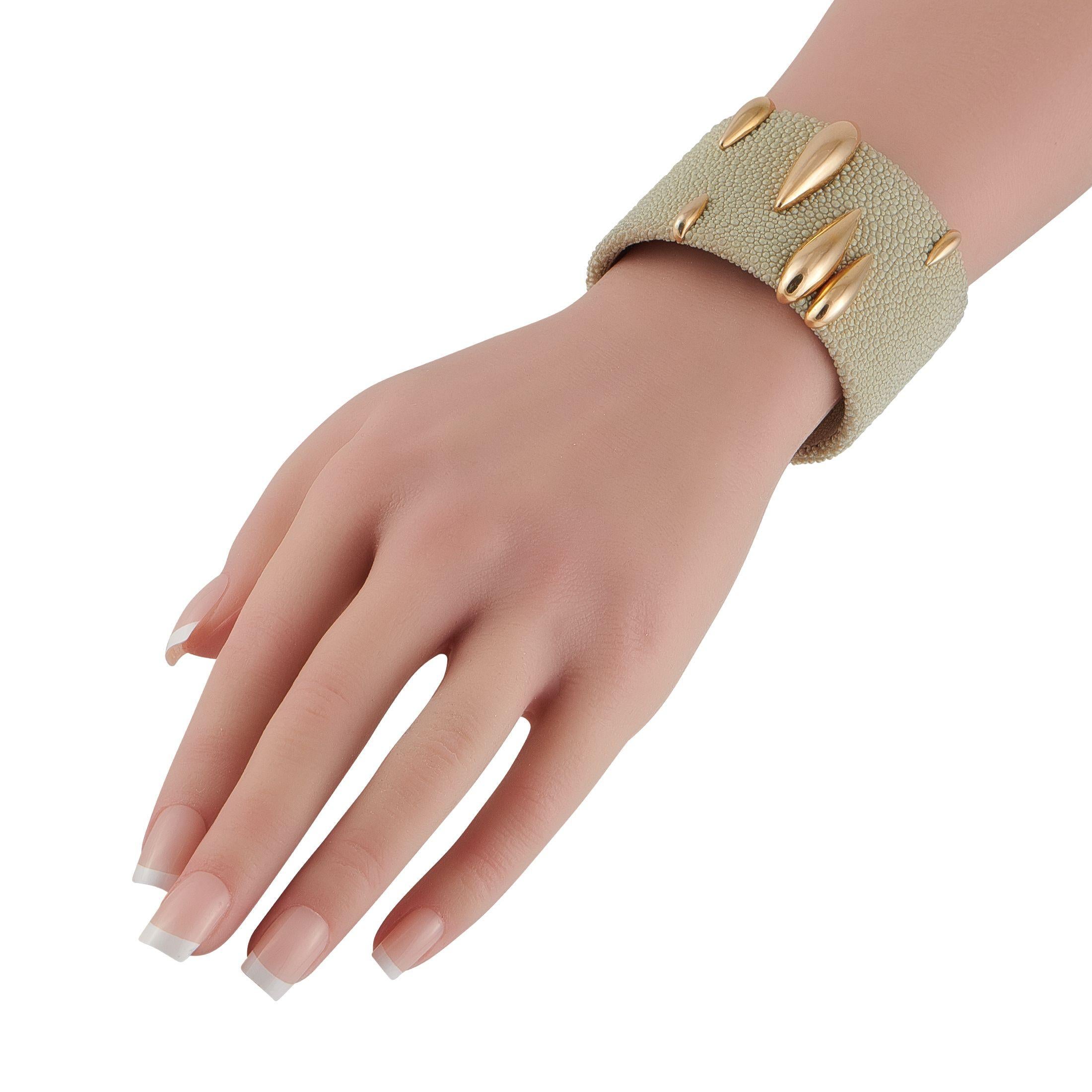 Ce bracelet manchette Galuchat de De Grisogono est un modèle d'affirmation à la pointe des tendances actuelles. La manchette en cuir de galuchat taupe prend vie grâce aux accents brillants en or jaune 18 carats. Il mesure 6,5 cm de long et