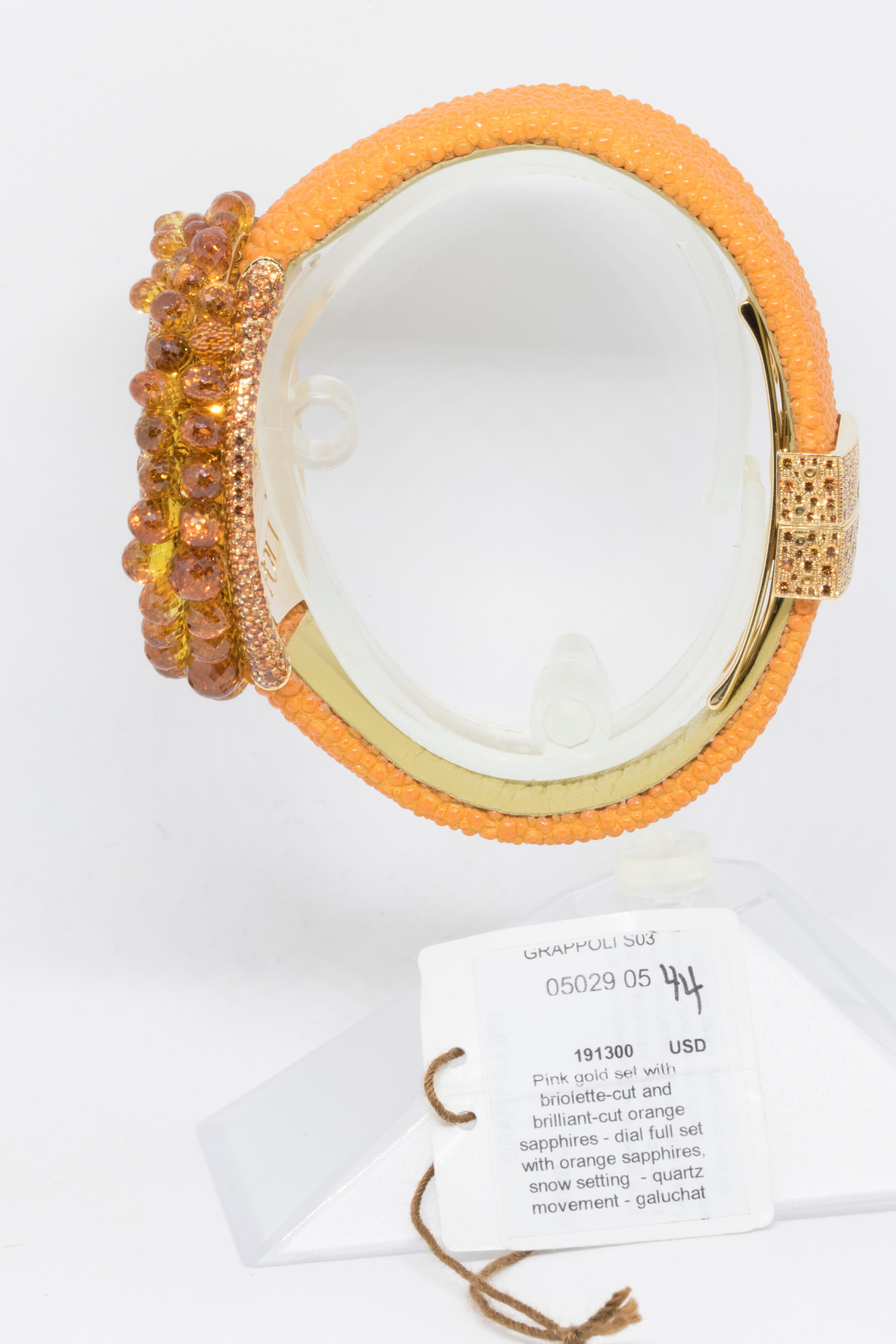 Vibrant and dazzling this adorable timepiece from the exceptional Grappoli collection by de Grisogono comes with a round-shaped 18K rose gold case fully set with spectacular orange sapphires boasting numerous additional briolette-cut orange