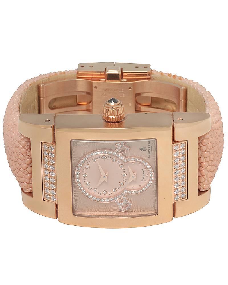 19K Rose Gold 29mm x 31mm Rectangle case. Brown Leather Strap with 18K Rose Gold Deployant Clasp. Fixed 18K Rose Gold Bezel Set with Diamonds. Pink Dial with Arabic Hour Markers. Off Center Hour and Minutes at 12 O’clock position. 2nd Time Zone at 6