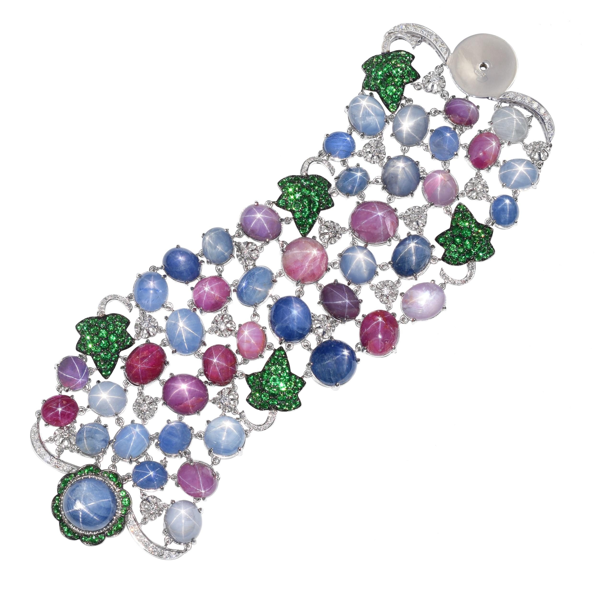 De Grisogono Star Sapphire and Star Ruby Bracelet.
Accented with round brilliant cut diamonds and round tsavorites. Inscribed de Grisogono. Stamped 750 and
makers mark. Equipped with screw in lock. Length: 7 inches. Width: approx: 60mm. Weight: