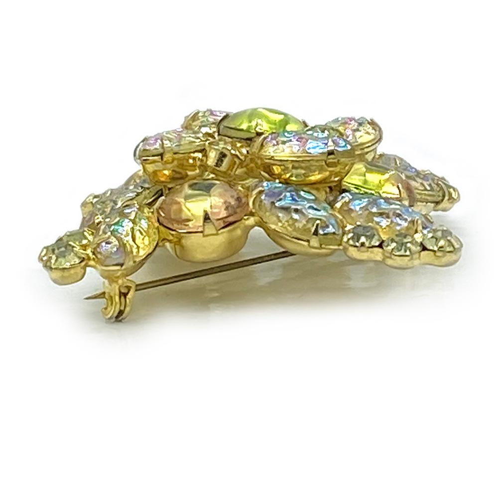 This is an identified 1960s DeLizza & Elster Juliana cartwheel like brooch. It comes with a combination of aurora borealis coated yellow molded navette, peach/lemon cabochon and smaller yellow chaton rhinestones. Please see page 182, Juliana Jewelry