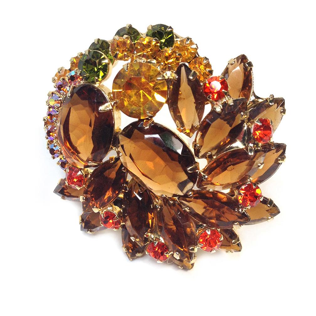 This is an identified 1960s DeLizza & Elster Juliana topaz rhinestone brooch. It's a combination of oval and navette topaz glass stones and green, gold & orange round rhinestones. Plus a touch of aurora borealis coated golden stones. They are all