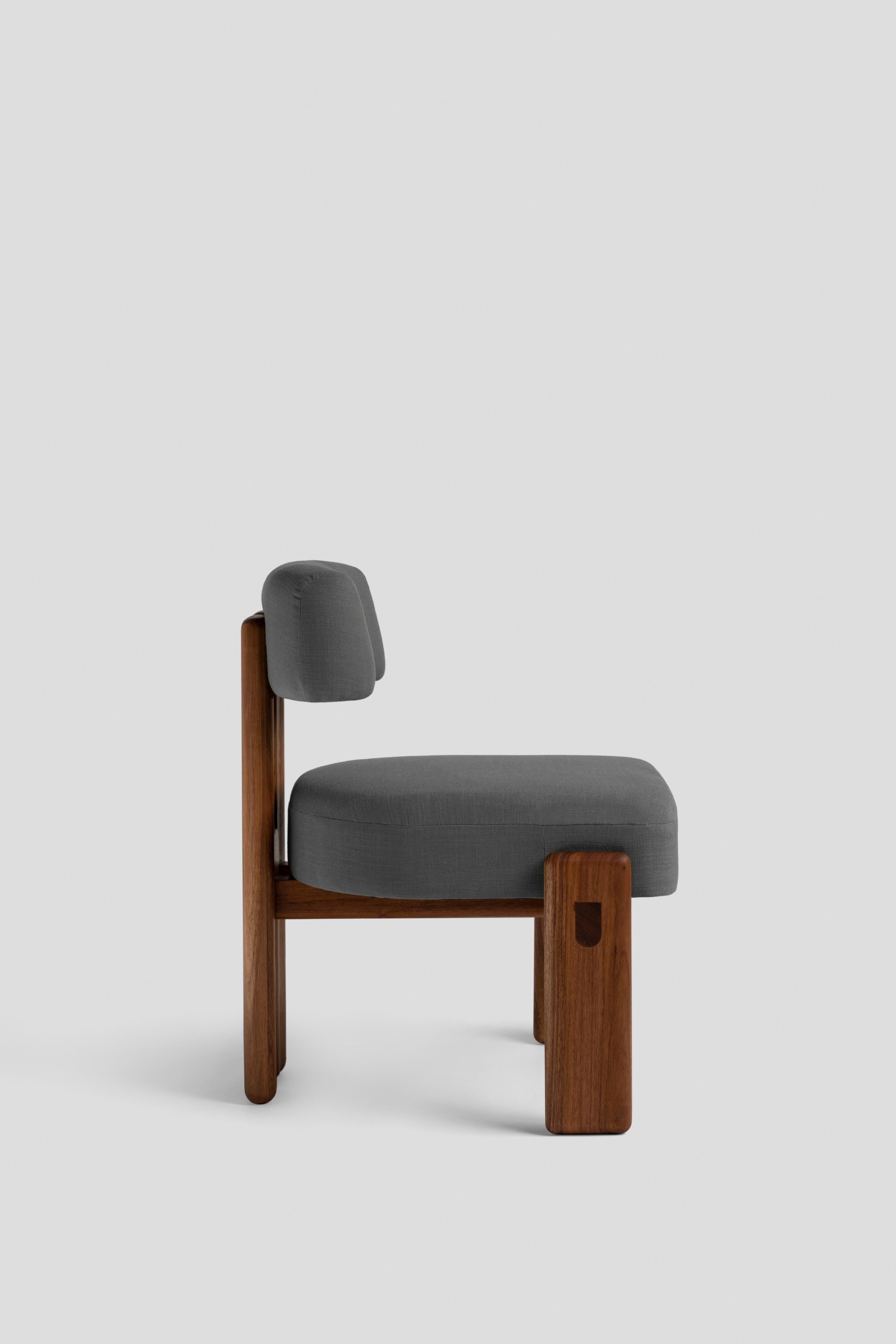 Chair with seat and back upholstered in fabric.
The backrest formed by a half-moon hugs the back giving it support. Inspired by the three-legged chairs, the Peace chair has a back leg formed by two pieces joined together by means of a wooden circle