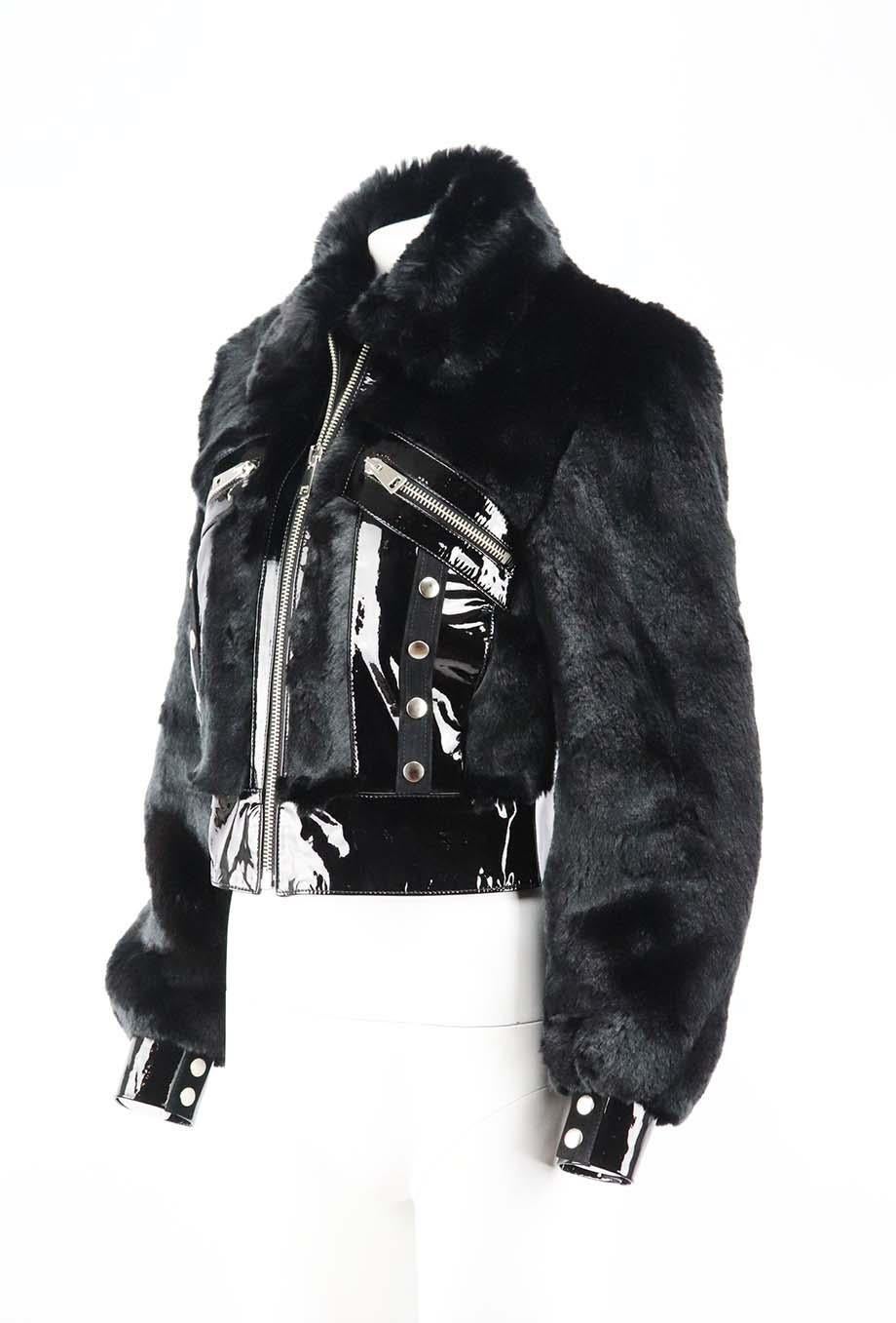 Diese Jacke von De La Vali ist den Modellen der Sirenen der 60er Jahre nachempfunden. Sie ist aus glänzendem Lackleder in einer kastenförmigen Form gefertigt und an Kragen und Armen mit farblich abgestimmtem Kunstpelz besetzt. Schwarzer Kunstpelz,