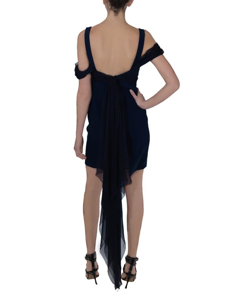 Gianfranco Ferre fitted dress with swathes of midnight blue chiffon gathering across the bust and dropping around the tops of the arms and into the back where it ties for added drama and gives the effect of a train.

Gianfranco Ferre label. Silk and