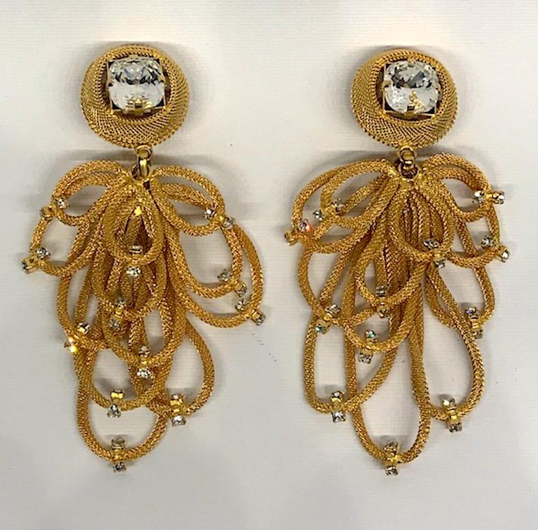A dramatic pair of 1980s gold tone chandelier earrings of mesh loops with rhinestone accents by Italian fashion company Di Liguoro. Each pendant consist of 12 mesh tube cord loops in various lengths suspended from a mesh button top with large