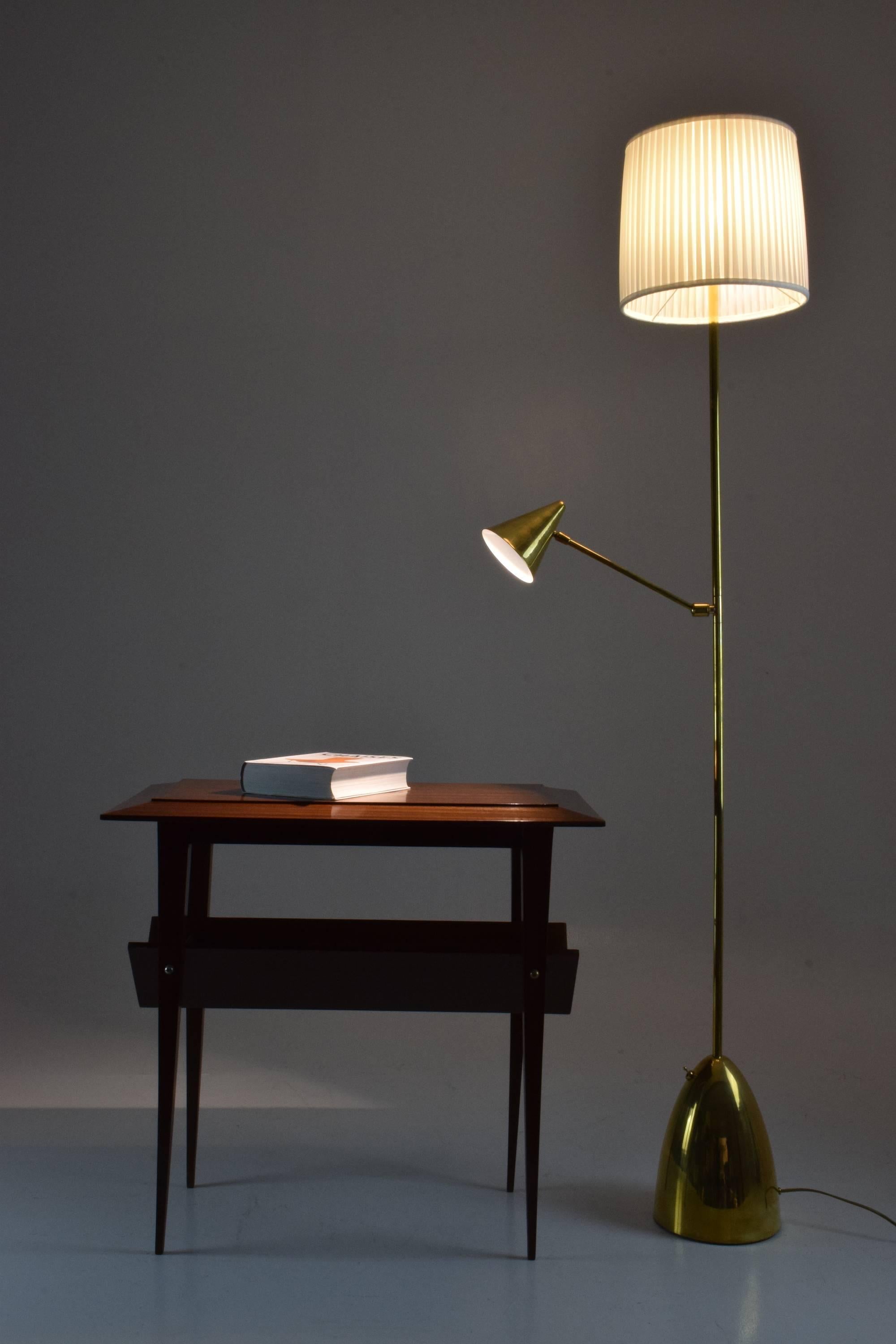 Un lampadaire conçu avec une liseuse placée à mi-longueur qui articule un abat-jour conique en laiton afin que vous puissiez diriger la lumière avec facilité. Les deux systèmes d'éclairage fonctionnent de manière indépendante, ce qui en fait un