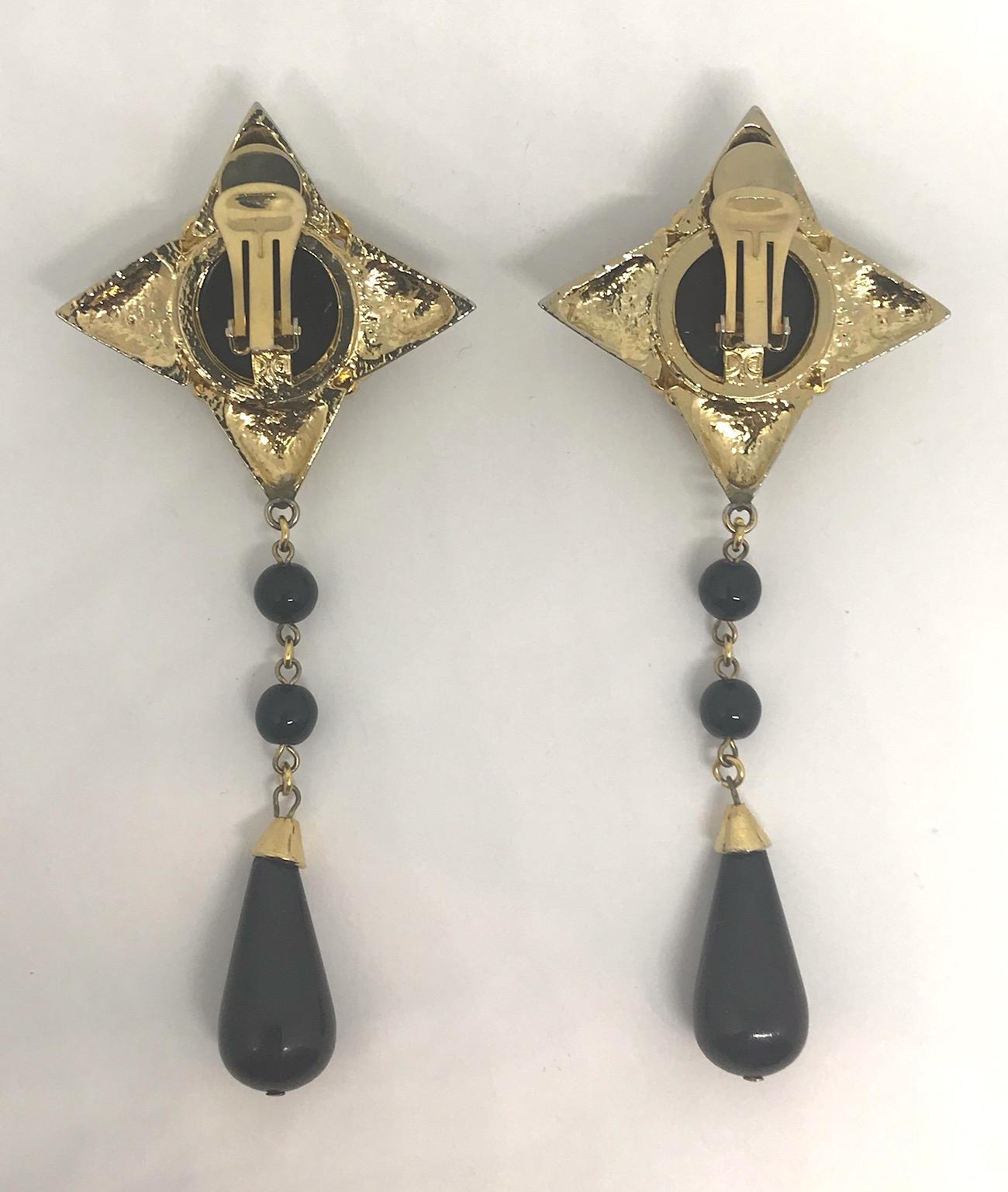 A stunning pair of De Liguoro four point star earrings with large molded lucite black cherry cabochon and black lucite bead pendants from the jewelry collection of Italian actress Elsa Martinelli. Each star is 2 inches wide and high. Including the