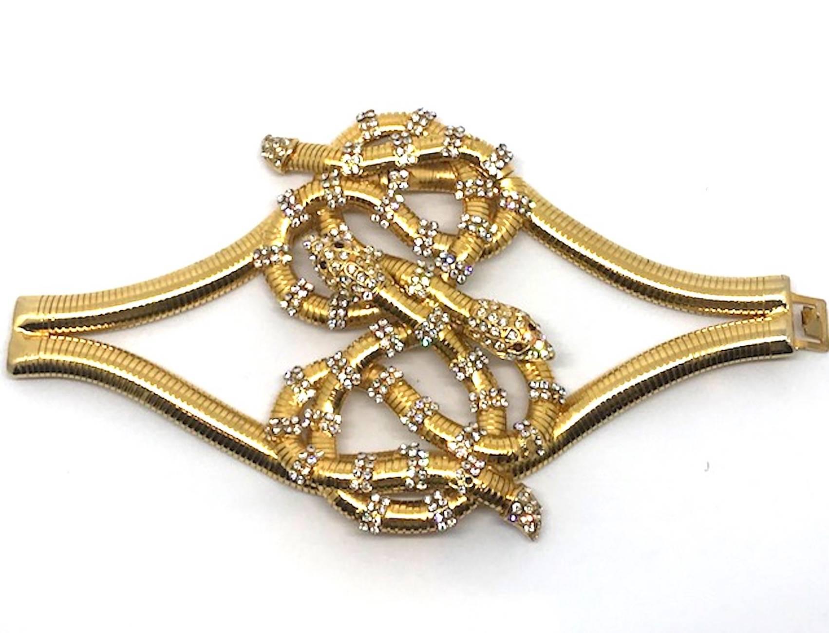 A true show stopper is this large gold plate with rhinestone accent layered large knot of serpents bracelet from the 1980s. The bracelet is from the personal collection of fine and costume jewelry of Italian actress Elsa Martinelli. Several pieces
