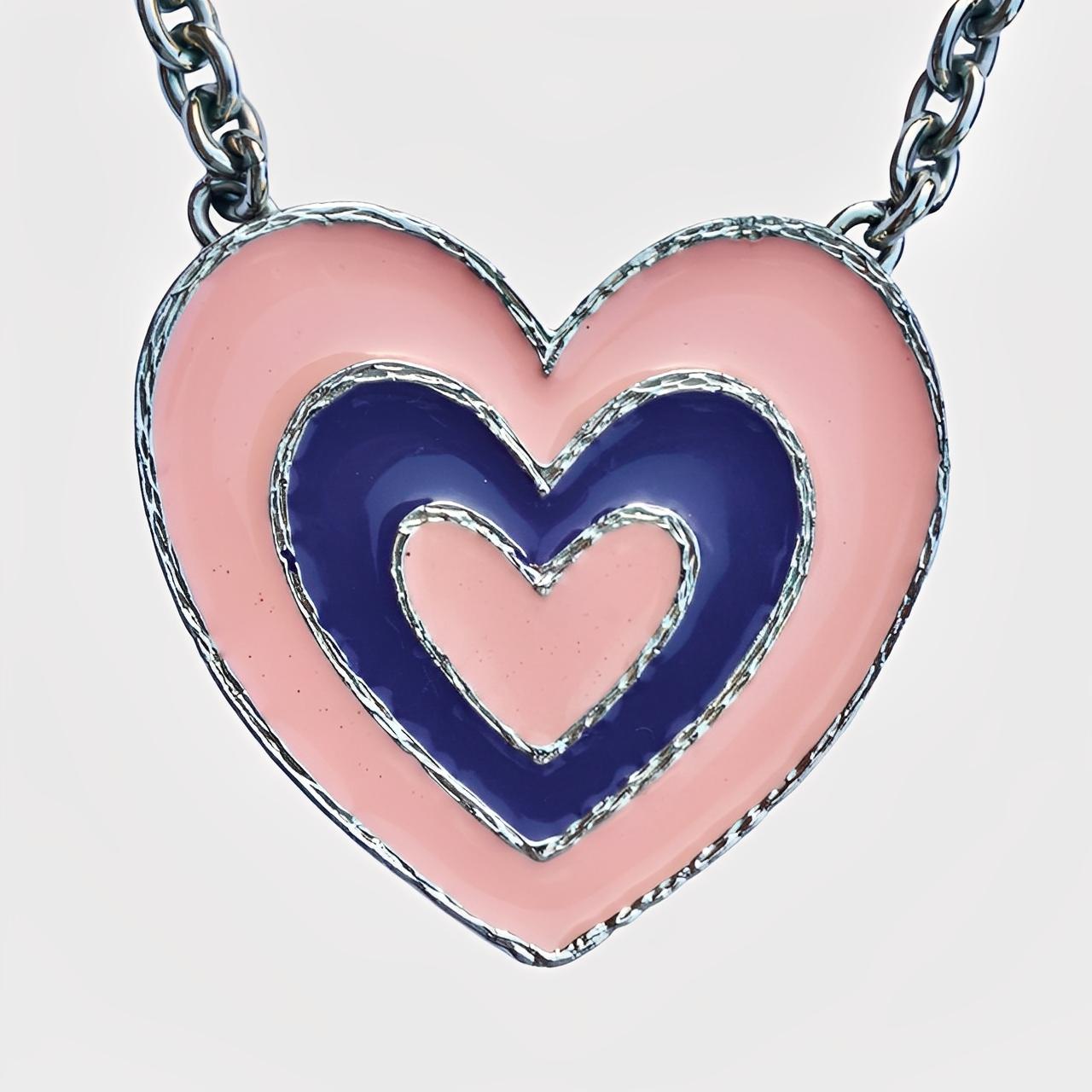 Collana con ciondolo a forma di cuore con smalto rosa e blu di De Lux A.Silver/A's.

Misura 41 cm di lunghezza. Il cuore misura 5,9 cm di lunghezza per una larghezza massima di 6,3 cm.

Questa audace collana dello stilista olandese Michiel Alexander
