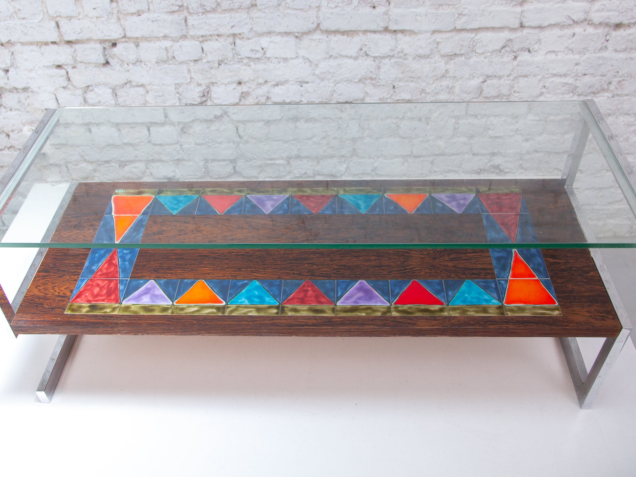 This stylish and colorful vintage tiled coffee table brings color to your interior! Signed at the top with Erpe. Equipped with a colorful tile tableau. Easy to install due to its modest dimensions. Designed in various materials, a chrome