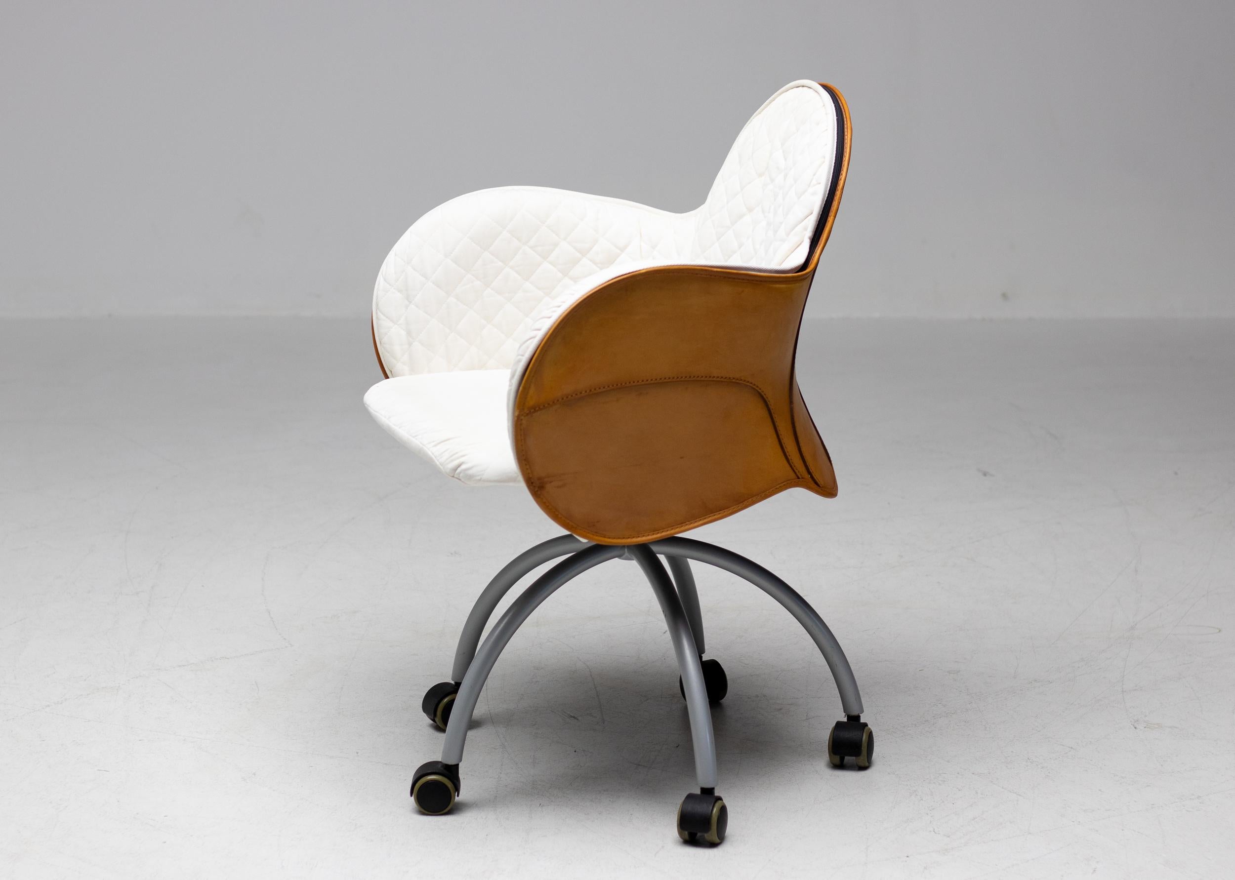 Incisa, designed by Vico Magistretti, is a swivel armchair on wheels with outer cowhide cover, like a saddle. Hand stitching adorns the back and sides, forming soft curves, precious to the touch. The comfortable padded inner covering, with cotton