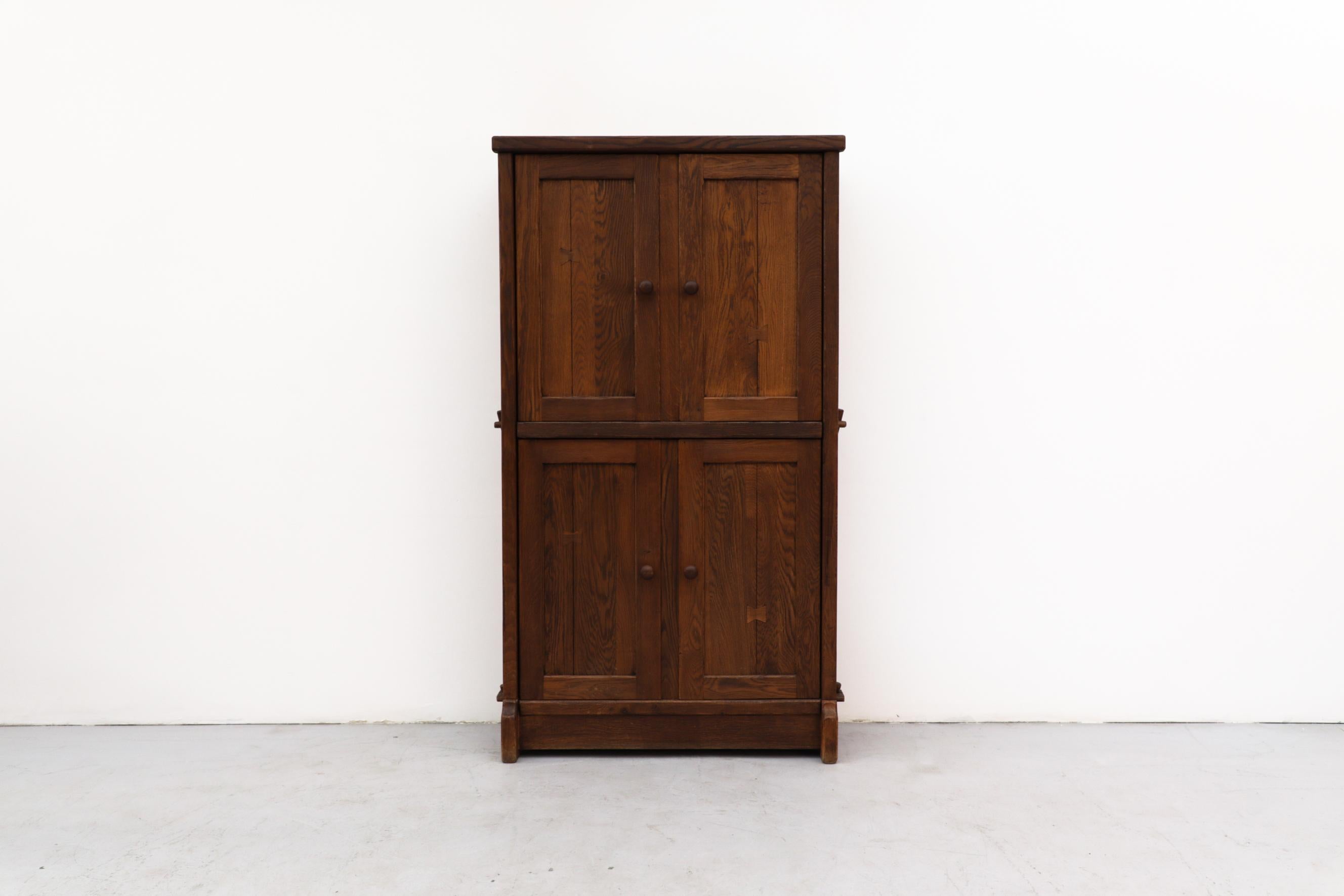 Large Brutalist oak cabinet with upper and lower double doors. In original condition with wear that's consistent with its age and use.
