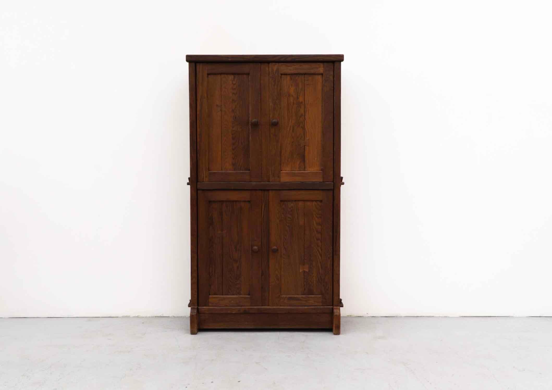 Large brutalist solid oak cabinet by de Puydt with upper and lower double doors. Peg tension construction. The door handle also is the latch. 
Belgium, 1970's.