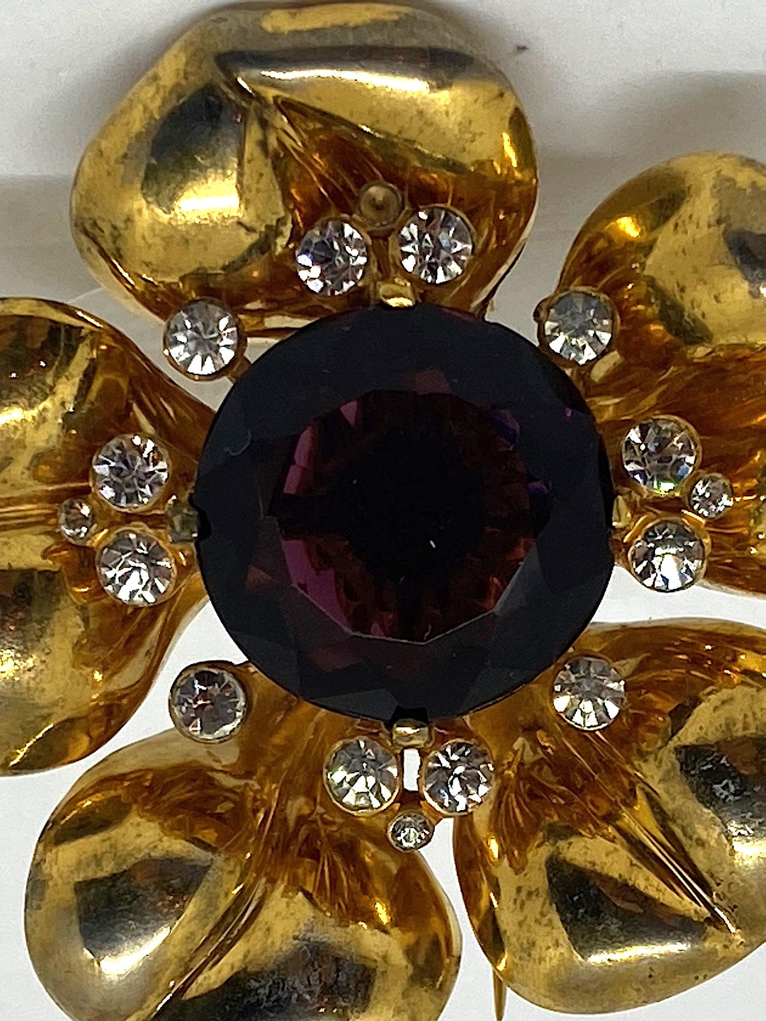 

An incredible 1940s large and three dimensional flower fur clip from the fashion costume jewelry company De Rosa. It measures 2.5 inches in diameter and 1.25 inches deep. The five petals are one cast piece. Inside this, is the center of the flower