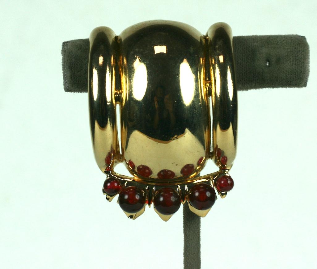 Ralph De Rosa Machine age 14 karat gold plated fur clip from the 1940's.  The Retro atomic half spherical clip is enhanced with two sizes of faux dark ruby beads. 
Excellent Condition, Signed DeRosa. 1940's USA.
L 2 1/16