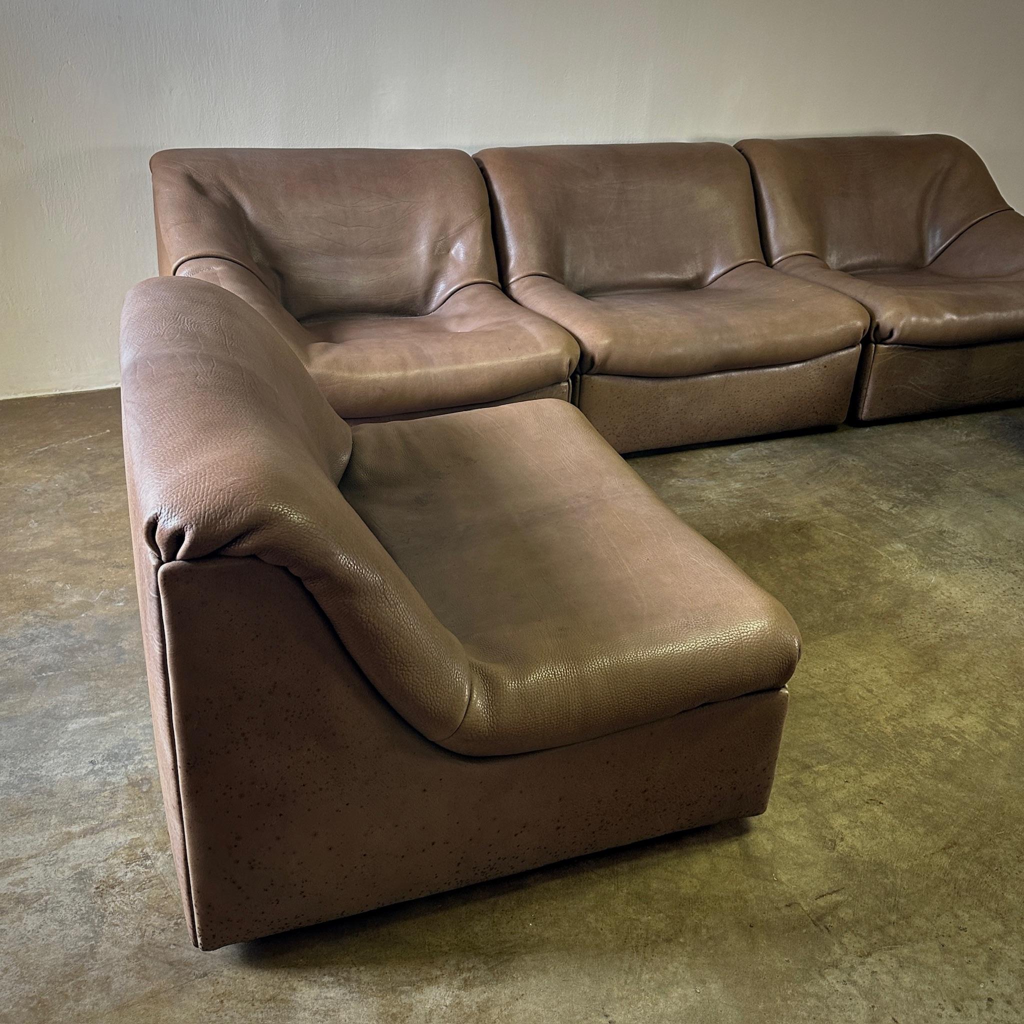 This De Sede five-piece sectional sofa set in softly worn brown leather offers multiple arrangement possibilities. Versatile and classic, this ensemble is perfect for accommodating various spatial layouts while providing timeless comfort and