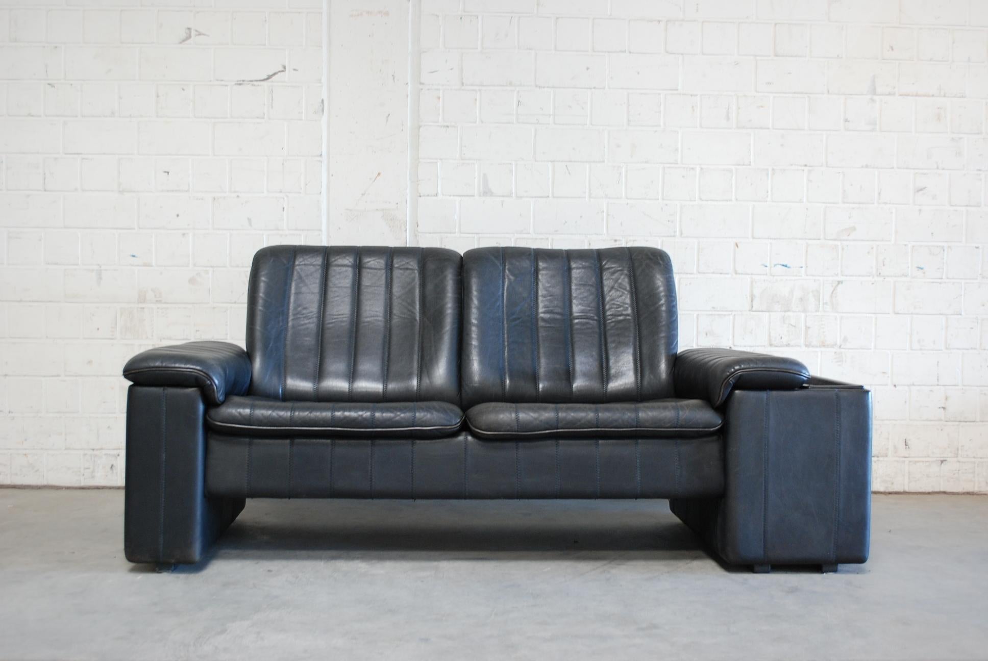 De Sede leather sofa in antracite color.
The sofa has on the left and right armrests a hidden tray folder.
Nice leather details with seam stitches. Design from the 1970s.
De Sede is known for best leather craftman quality from Switzerland.
 