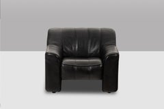 De Sede. Armchair and ottoman in black leather. 1970s